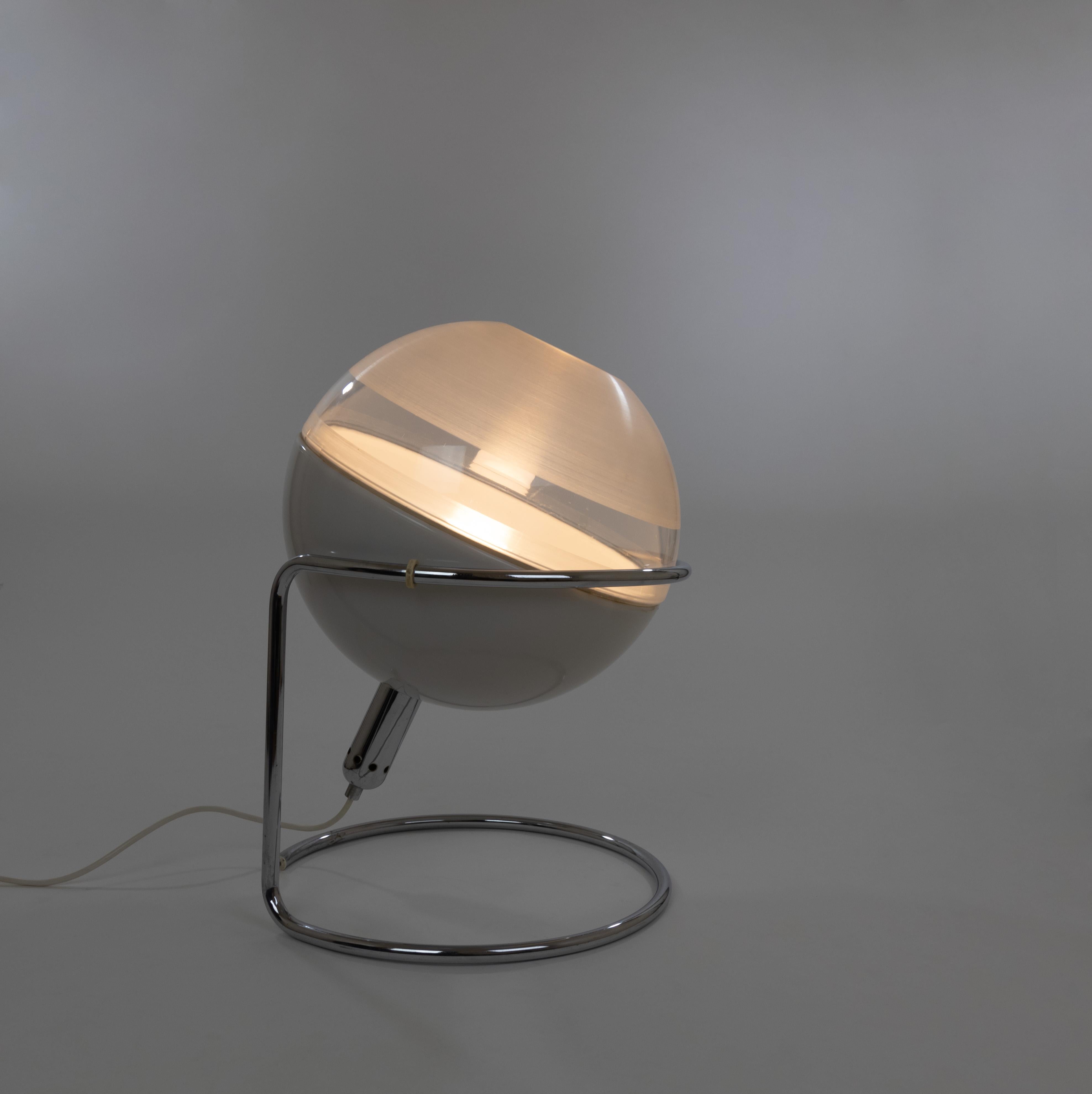 Focus table lamp, designed by Fabio Lenci and manufactured by Design House Guzzini in the 1960s.

The lamp consists of a chromed metal frame in which the sphere can be oriented in any direction. The chrome-plated bulb holder can be positioned into