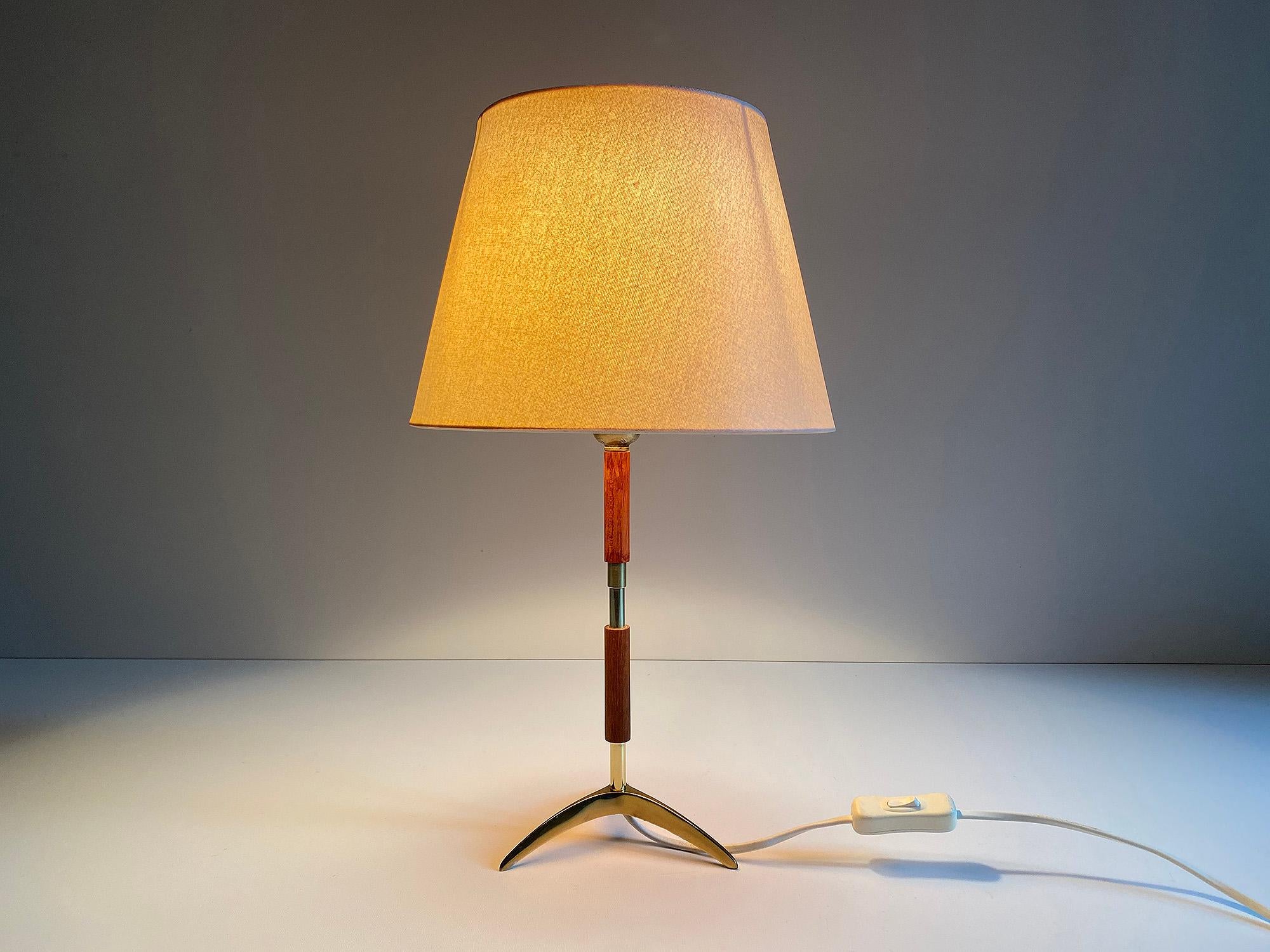 Midcentury Fog & Mørup Denmark table or desk lamp, featuring a bronze tripod base, teak and brass stem, laminated fabric shade in cream color
Wiring: The lamps have been tested with US American light bulbs under 120v and they work flawlessly.