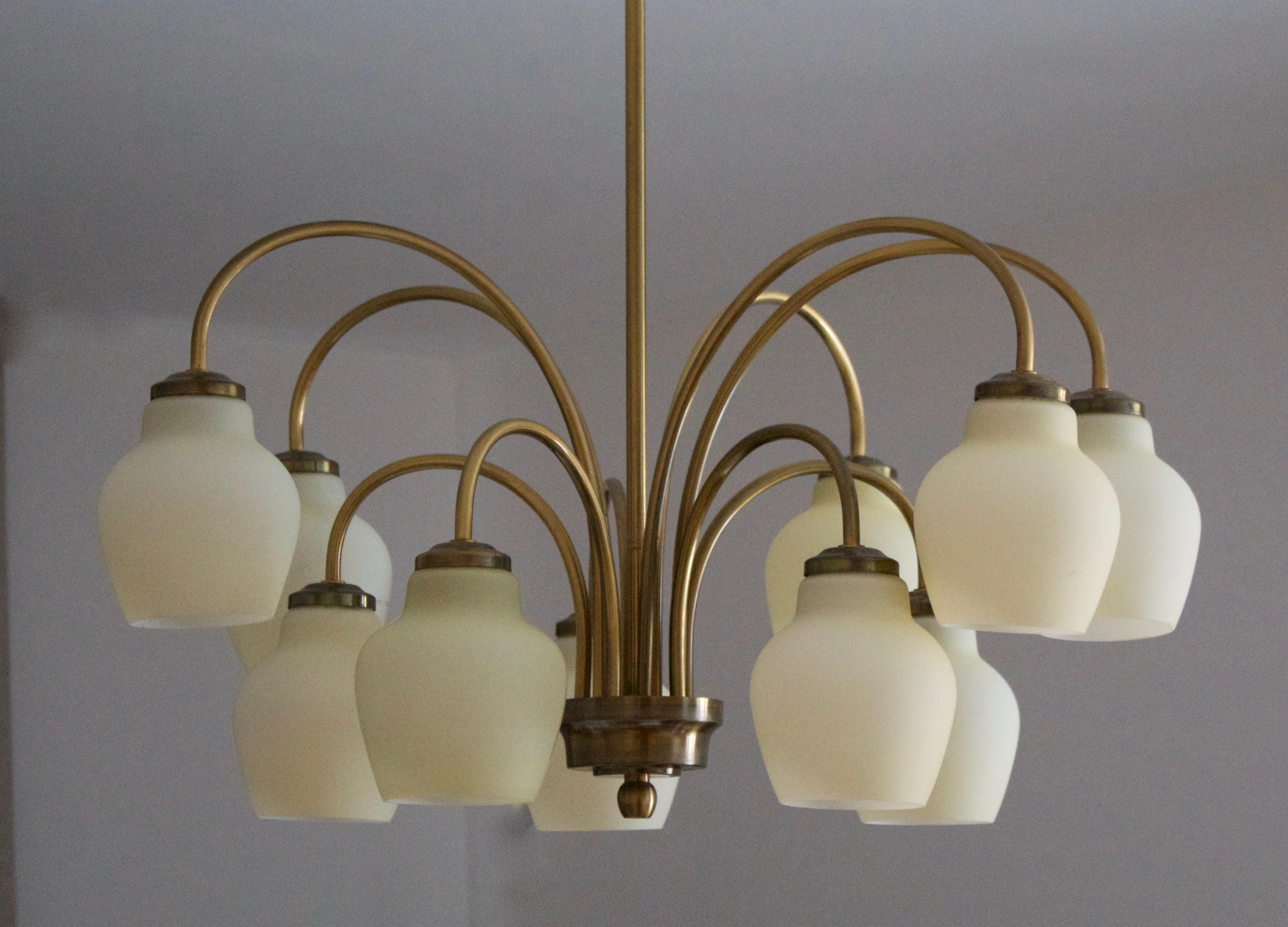 A sizable 10-armed chandelier light. Produced by Fog & Mørup, Denmark, 1930s-1940s.

In brass, featuring its original milk glass difussers.