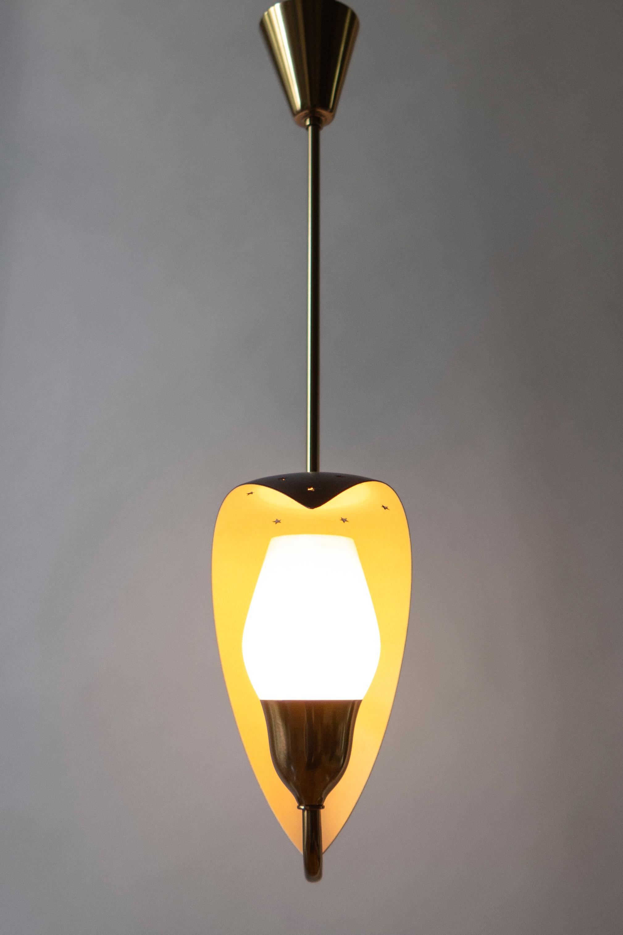The conical canopy, above a hanging rod issuing two s-curved brass arms, each arm surmounted by a crescent-form reflector pierced by star shaped perforations, each arm terminating in a tulip-form frosted glass diffuser. Stamped FM.