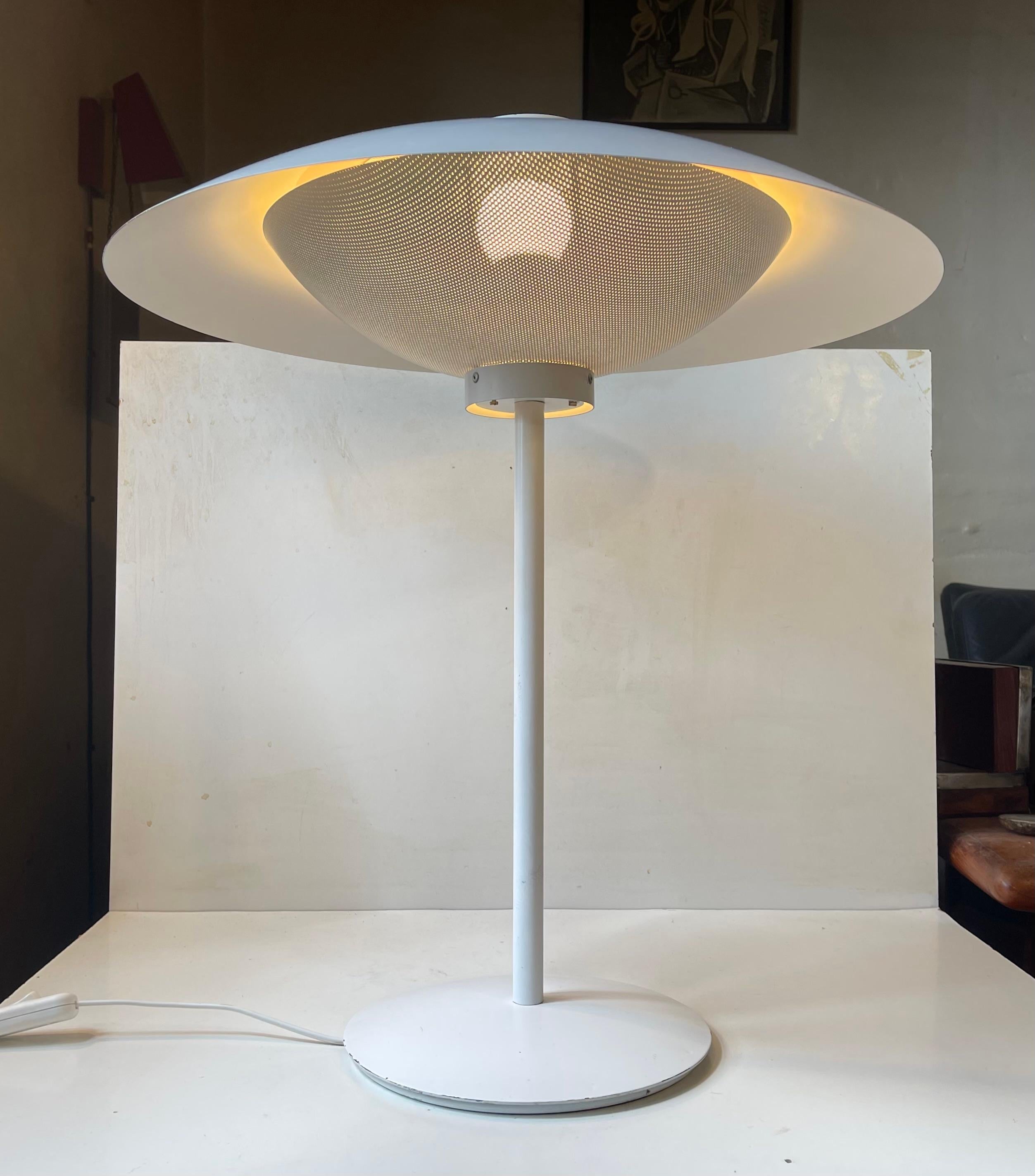 A large and rare table light in white aluminum designed at and made by Fog & Mørup in Denmark during the 1970s. It features a 3-tiered shade system much like the PH4 by Poul Henningsen. The piercet metal shades to the top and bottom serves as light