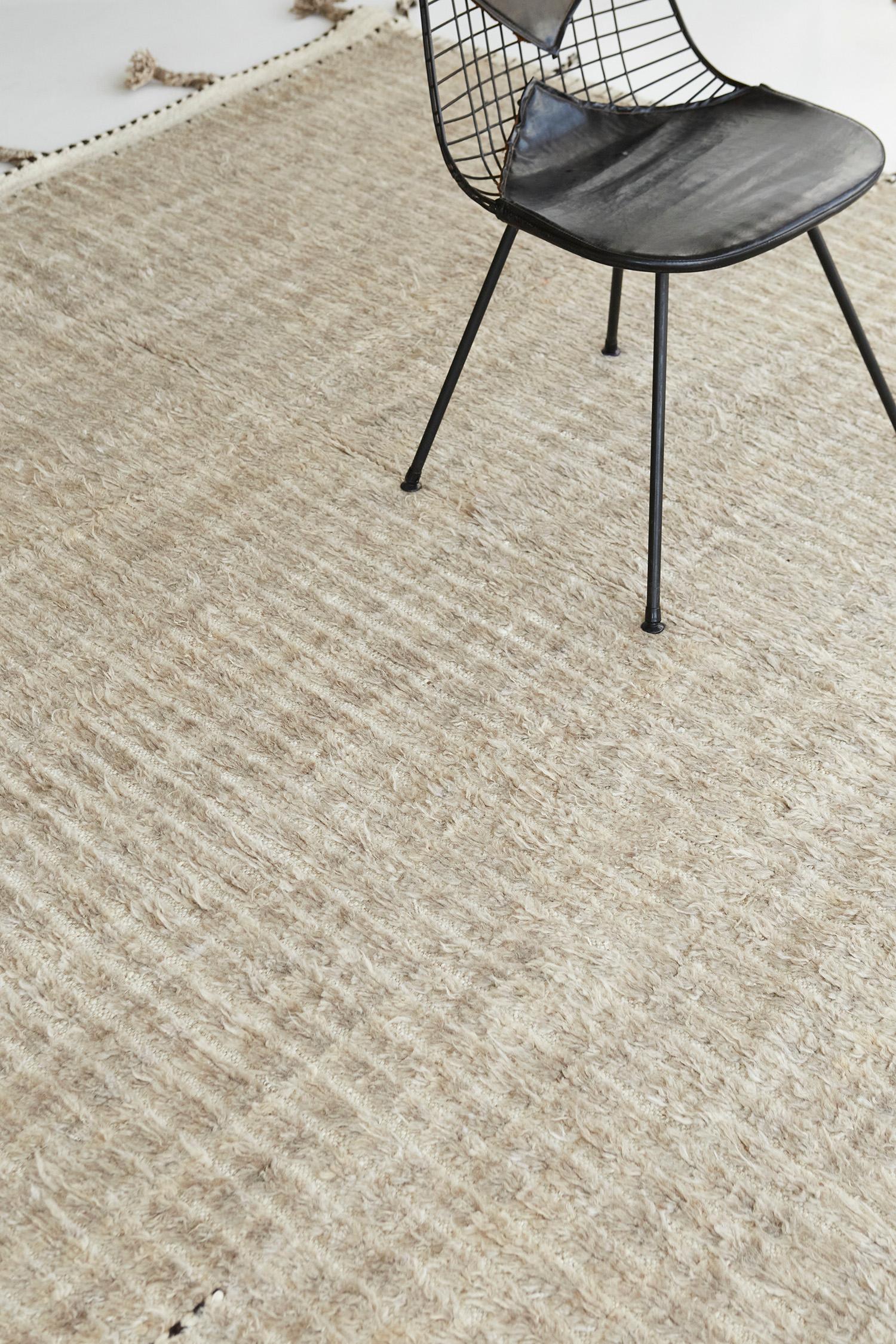 Fohn' is a handwoven luxurious wool rug with timeless embossed line detailing. In addition to its ivory-toned flat-weave, Fohn has a perfect shag that brings a lustrous and contemporary feel to one's space. The Haute Bohemian collection is designed