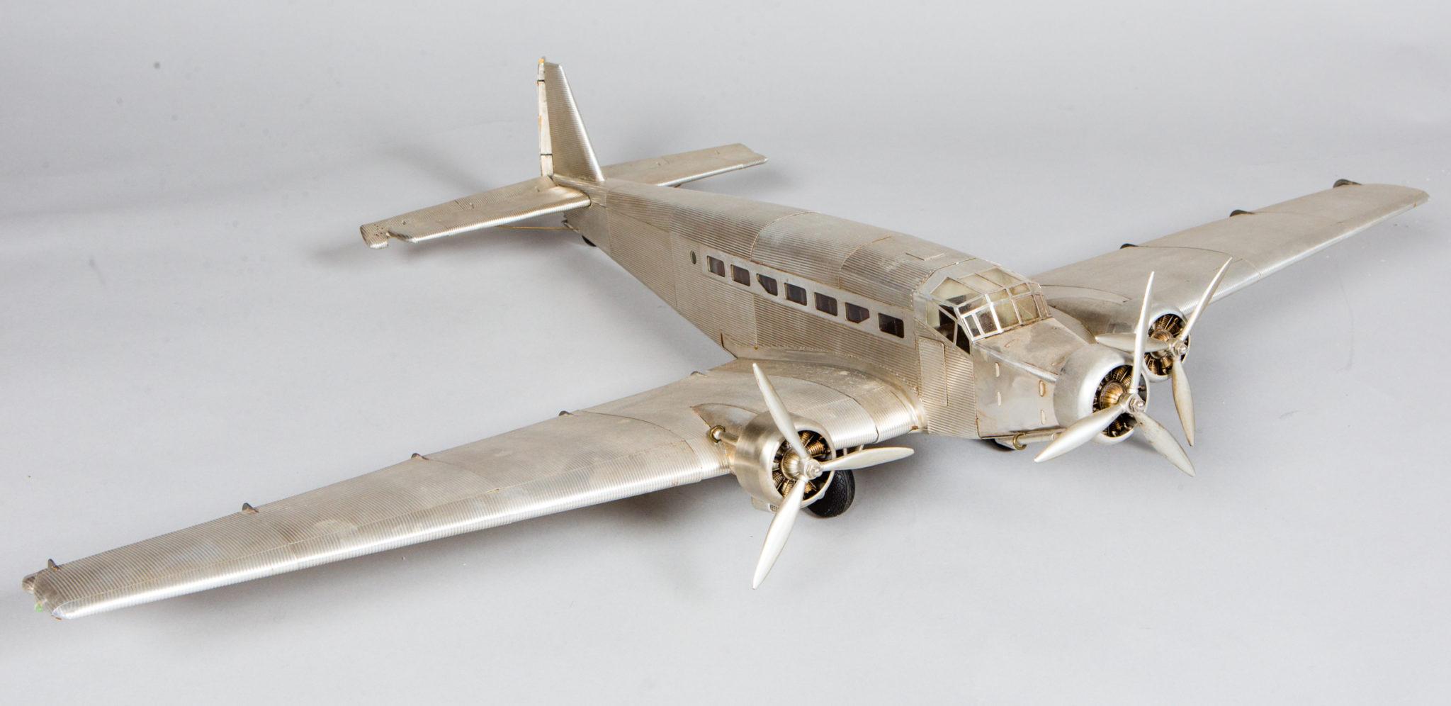 Metal model airplane with articulating control surfaces and propellers.