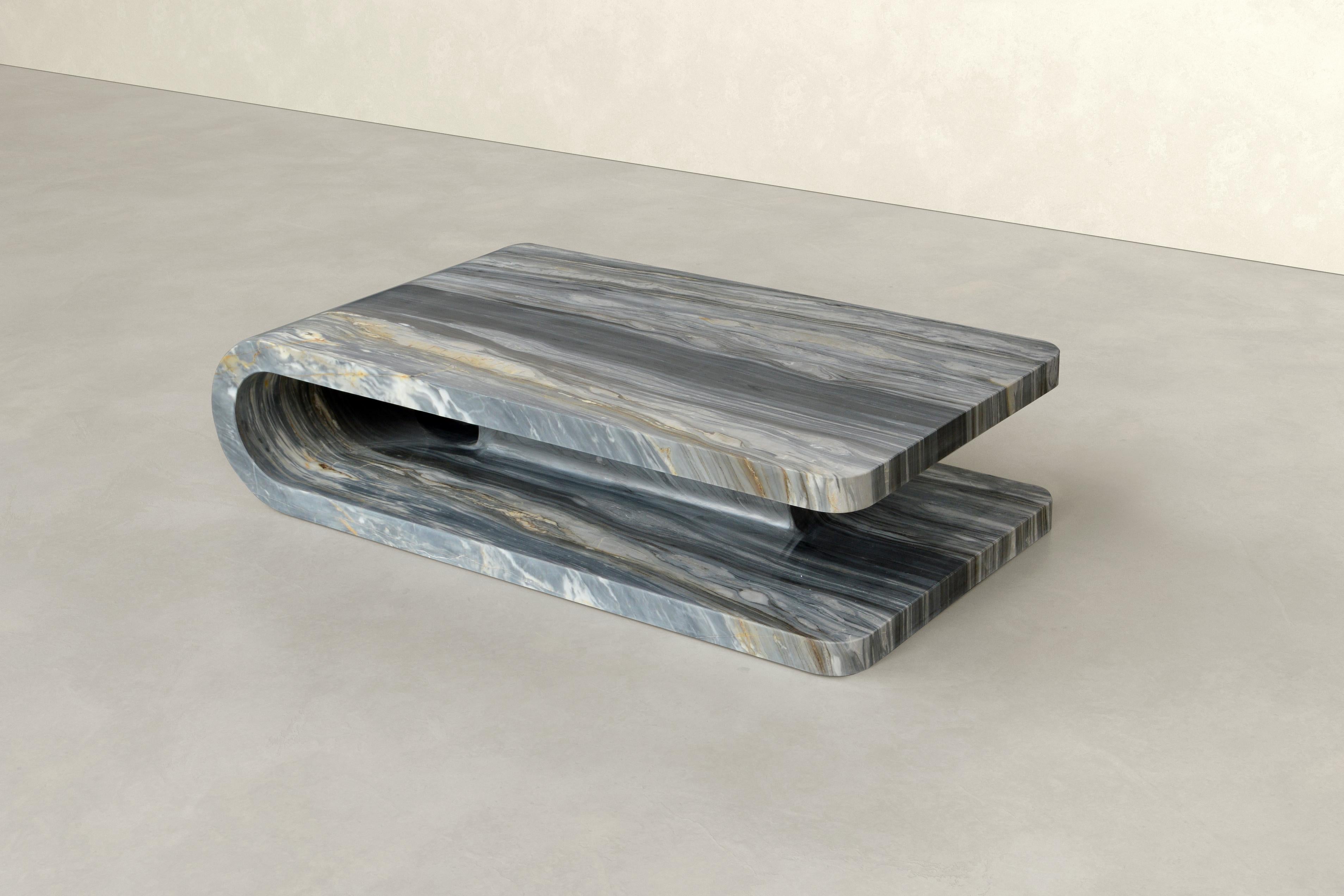 Carved from a single block of Calacatta Midnight, Fold embodies the seamless unity of material and form.

Its geometry challenges perception, making the rigid stone appear as if it were gently folded. This illusion of softness contrasts beautifully
