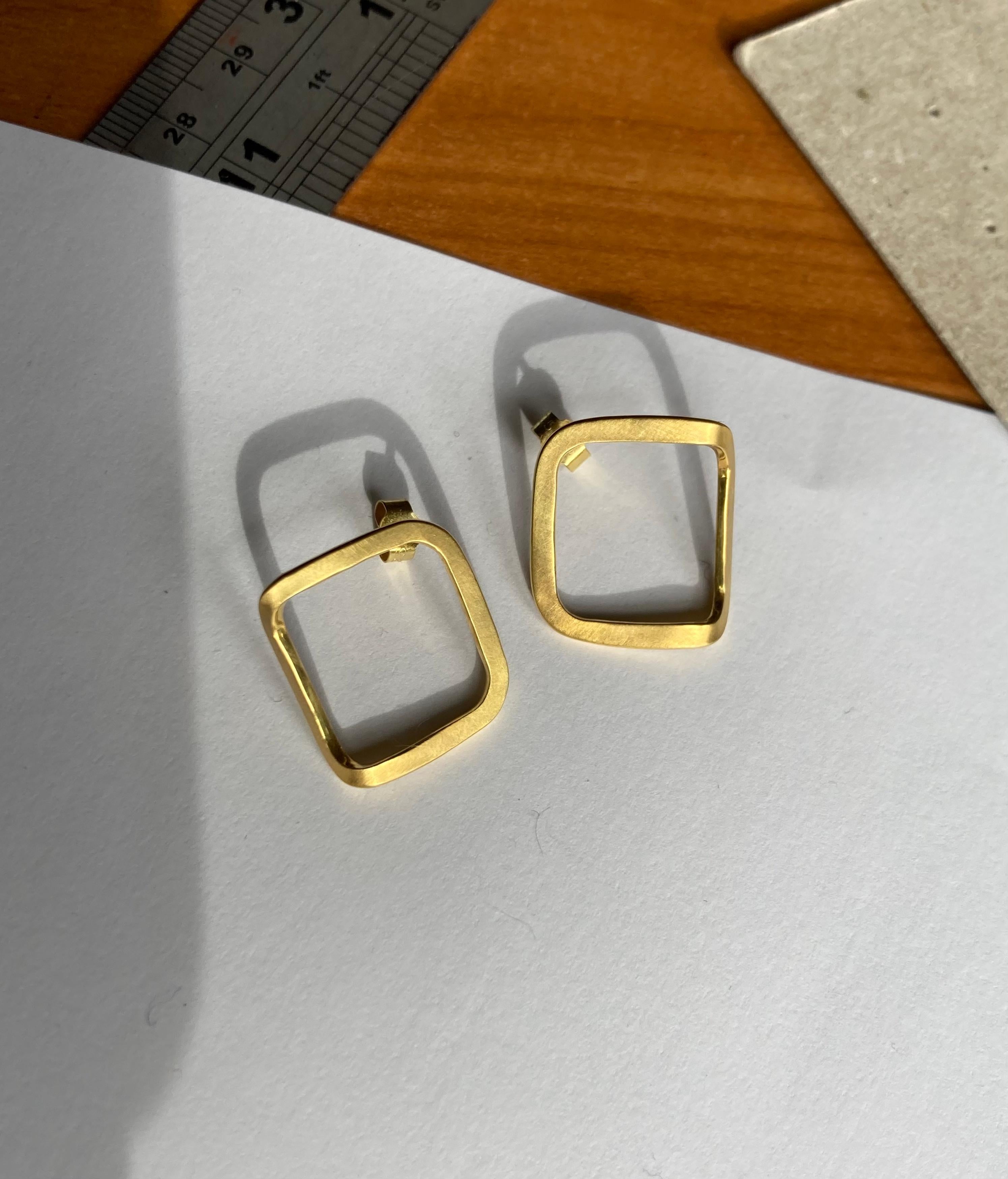 Elegant stud earrings made from forged wire, formed into a folded square. 

The polished inside surface is highlighted by the fold and catches the light when worn. 

They are secured to the ear with a classic butterfly back, and are a comfortable