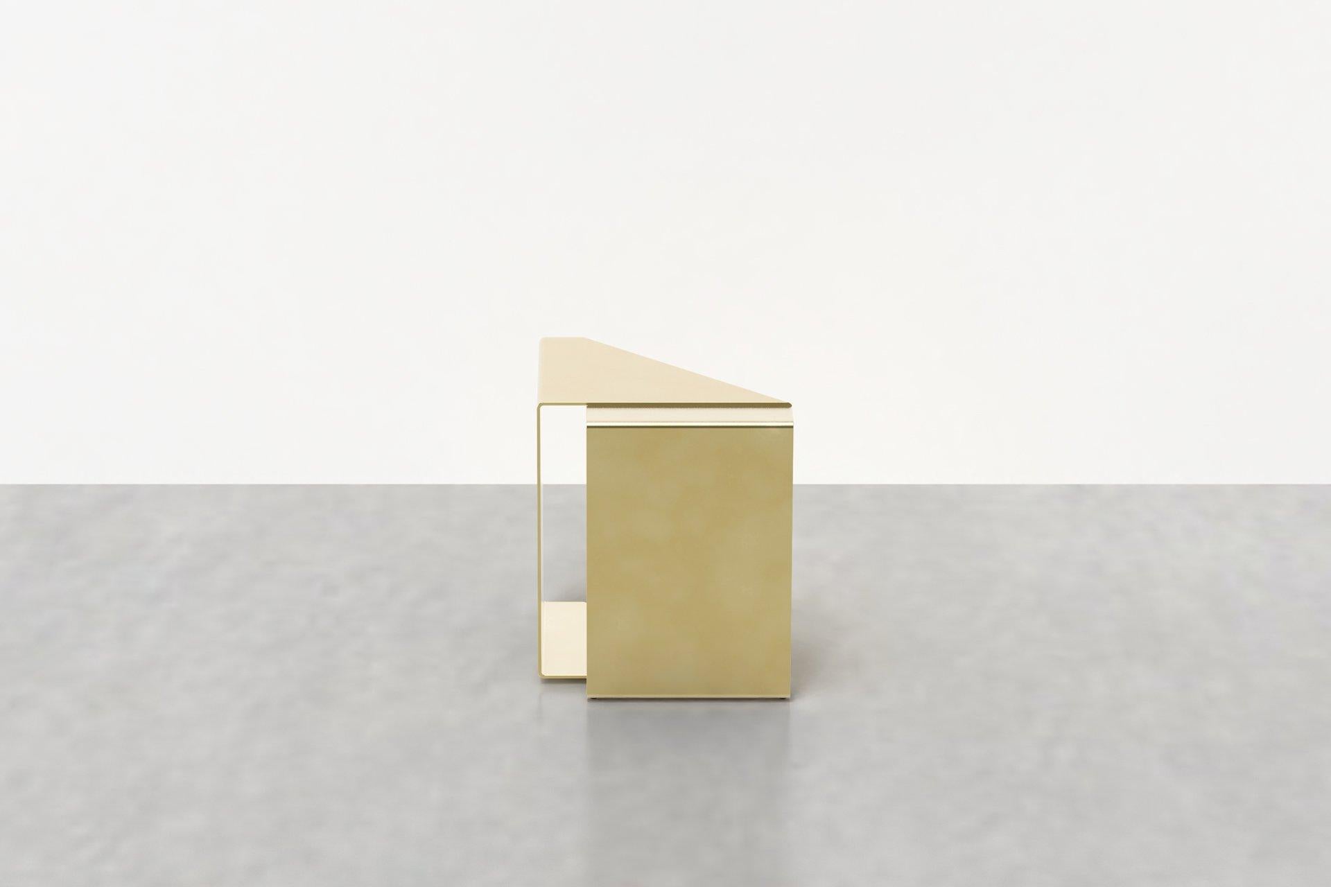The fold end table in brass reflects pliable strap shapes in sturdy, fixed forms. The fold end table in brass is handmade in our studio from solid brass, and available in a range of custom finishes inspired by the changing patina of metal as it is