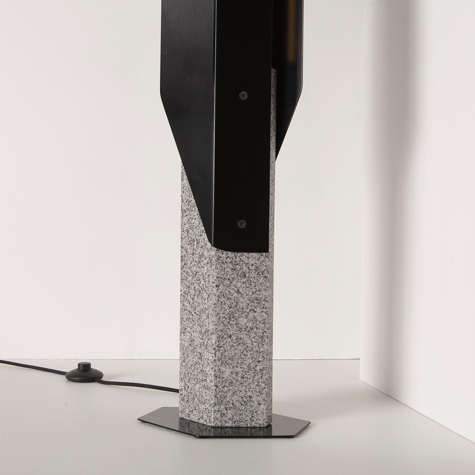 Inspirée de l'architecture angulaire et des ambiances sombres du chef-d'œuvre de Ridley Scott, Blade Runner (1982), la lampe Fold reflète une lumière ambiante vers l'avant et vers l'arrière grâce à deux ailettes en aluminium plié. La lampe est mise