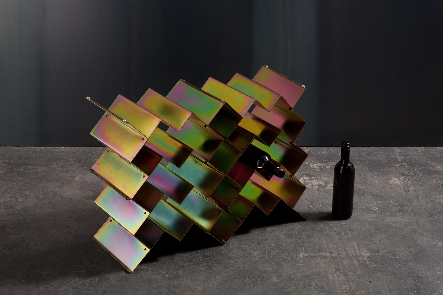 Fold wine rack is a Brutalist inspired modular design that can be stacked in a variety of sizes and configurations. Made from folded sheet metal with an iridescent zinc plated finish. The intention of the Fold collection is to express the purity of