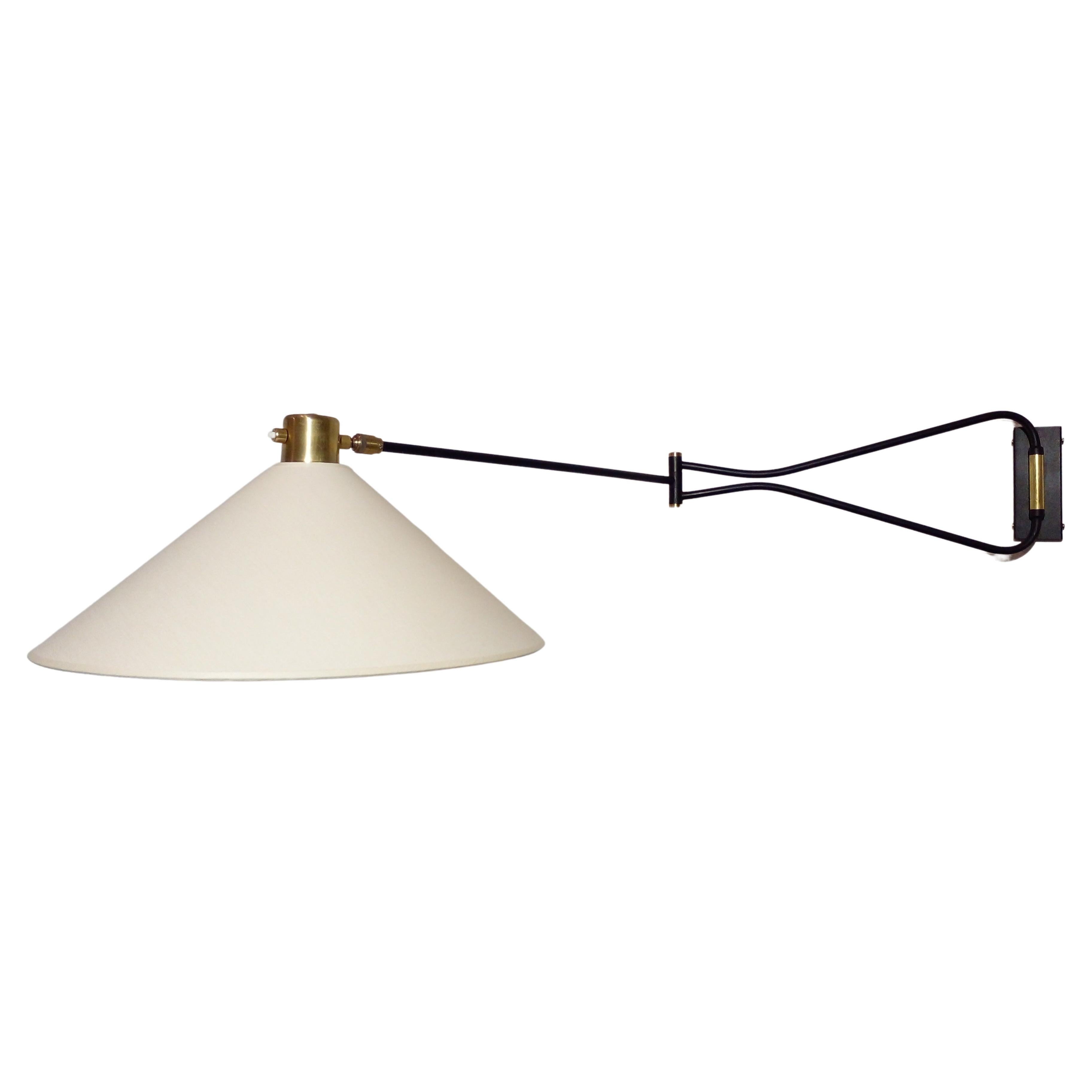 Wall lamp by Arlus Edition, France, circa 1950.
Black lacquered metal and brass, new cotton shade and light bulb cover redone as identical.
With two articulations at 360° and a patella above the lampshade.

A pair of wall lights
