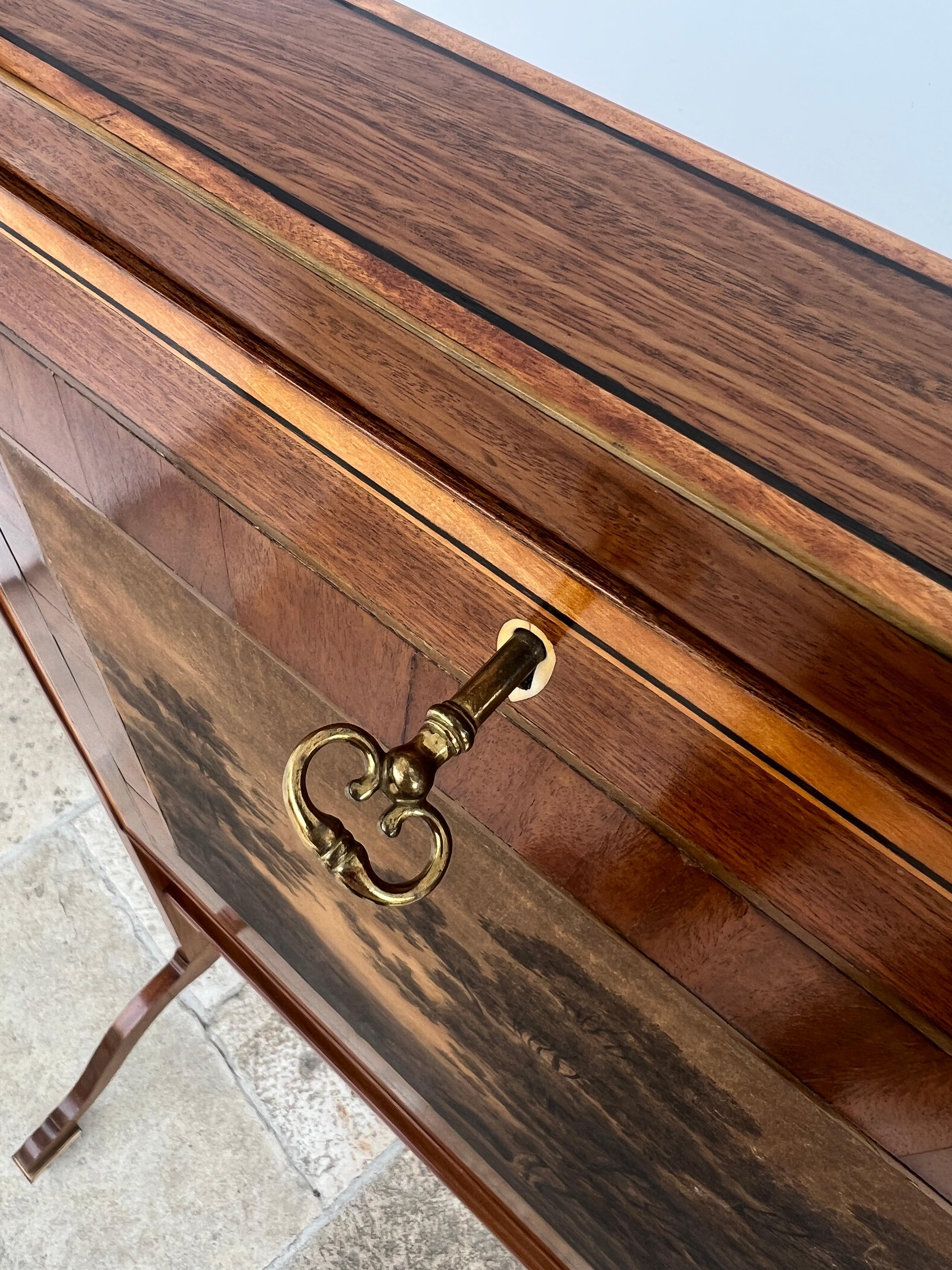 This filigree patent secretary, also known as a folding travel desk, is made of mahogany veneer and is decorated on the edges with fine thread inlays of boxwood and ebonized fruitwood. When closed, the front of the secretary reveals a beautiful ink