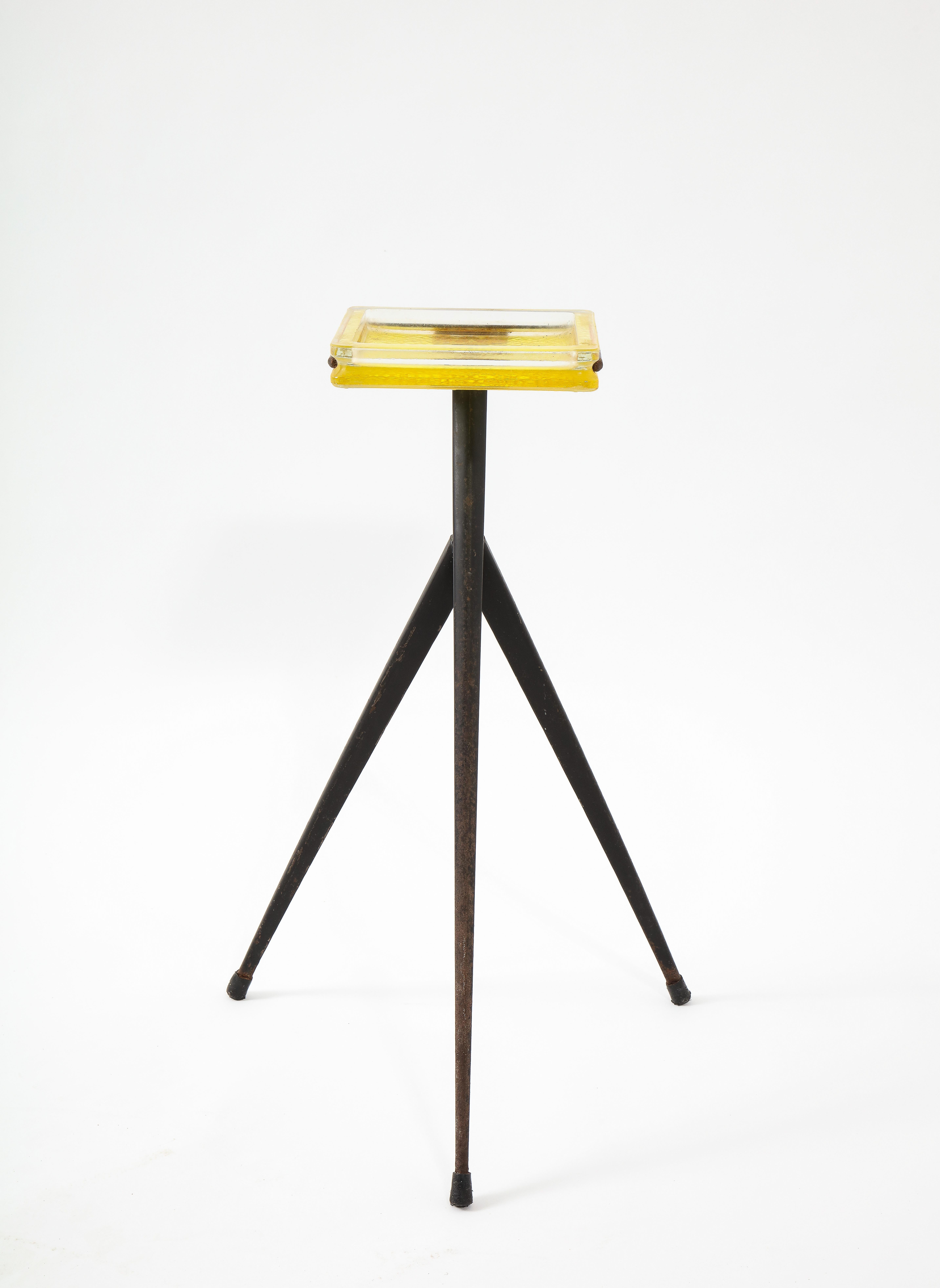 A drink stand in folded steel with a yellow glass tile top.
