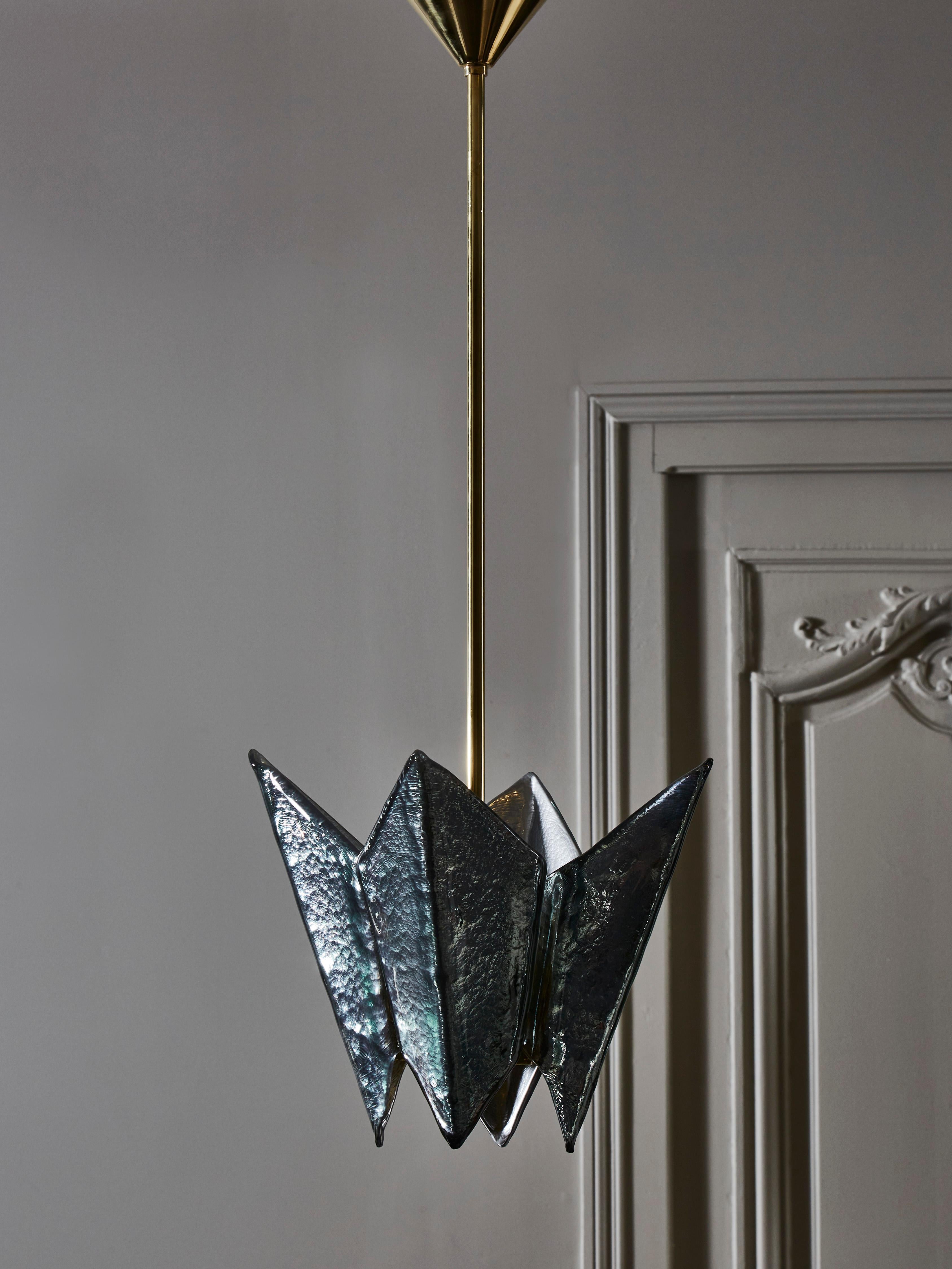Charming small suspensions made of a central brass rod and four sheet of glass folded like an Origami and tinted in metallic blue hiding the bulbs.