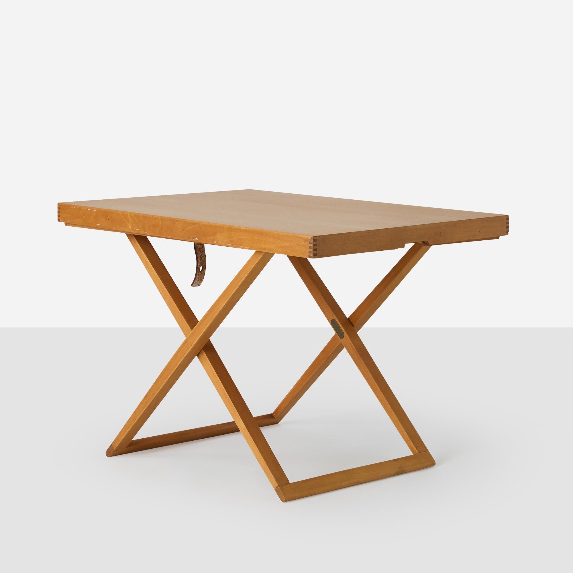 A beech folding table by Mogens Koch produced by Rud Rasmussens and signed with applied metal manufacturer's label to frame. Lightly restored. 