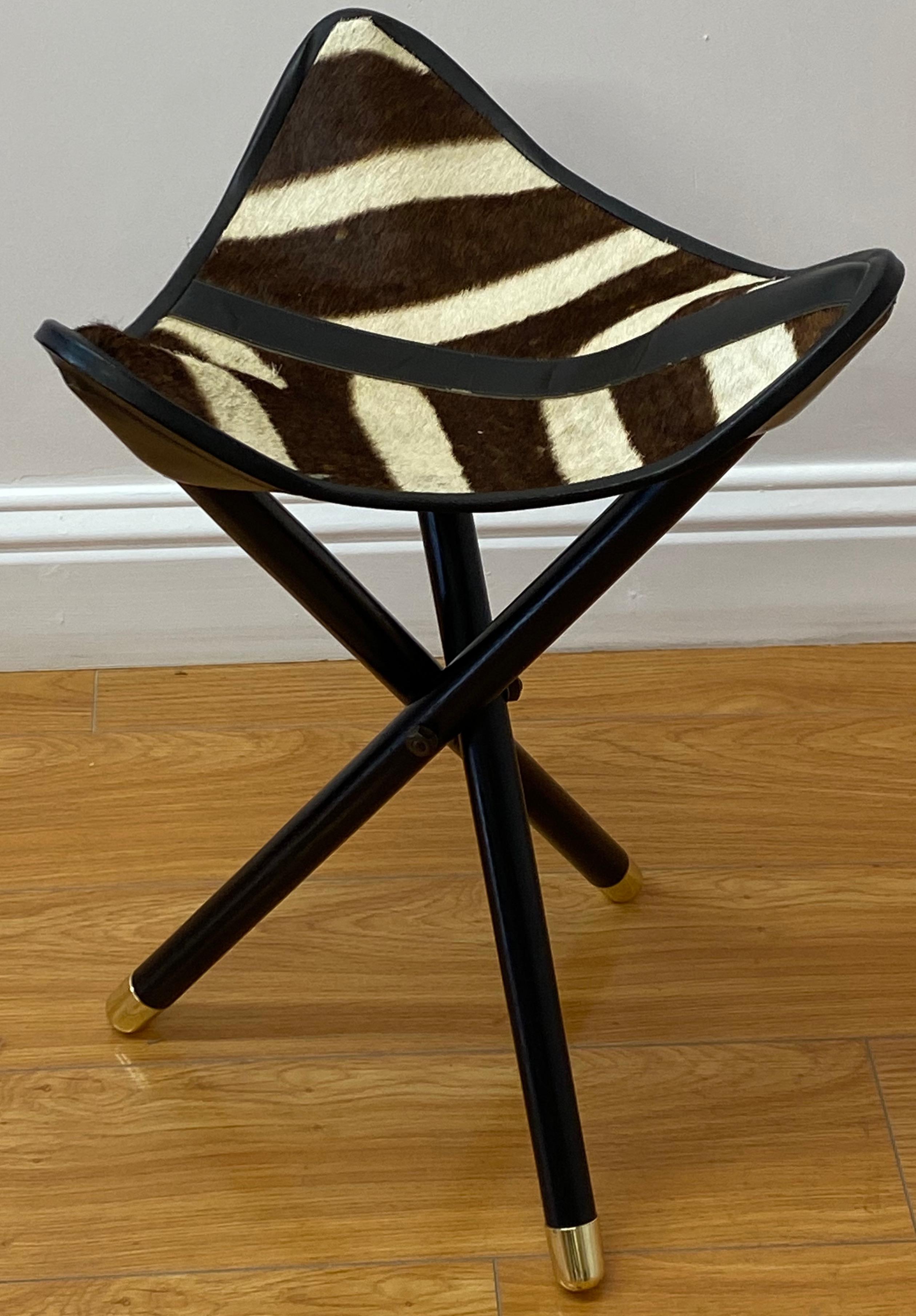 Folding campaign hunting seat with genuine zebra hide C.1970

The zebra hide and leather seat attaches to lacquered folding base

The seat measures 14