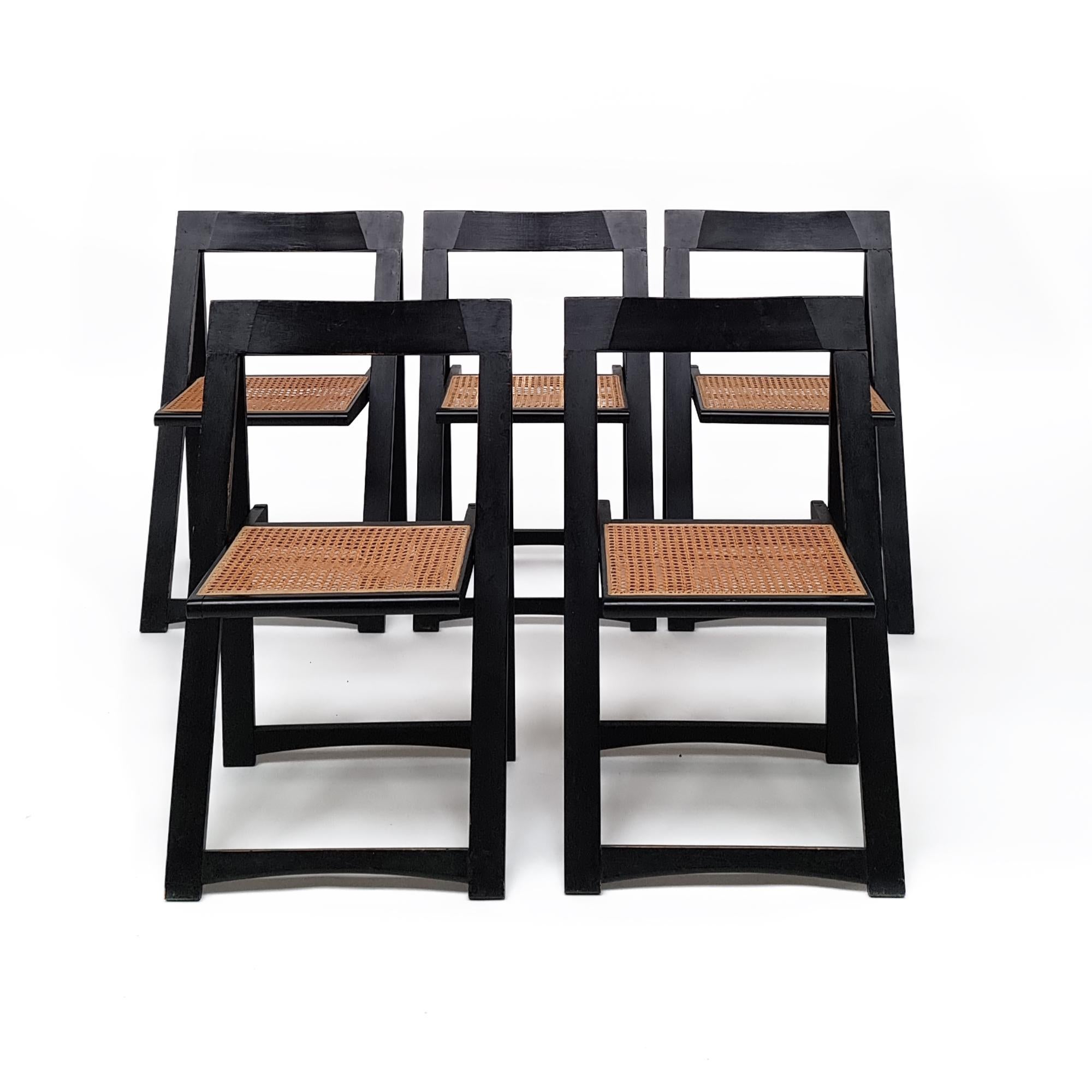 These chairs feature folding frames crafted from black lacquered wood and wicker seats. They are supported by braced legs, measuring H.75.5 cm with a seat height of 45 cm, and dimensions of W.46.5 cm and D.45 cm.  A folding chair from the