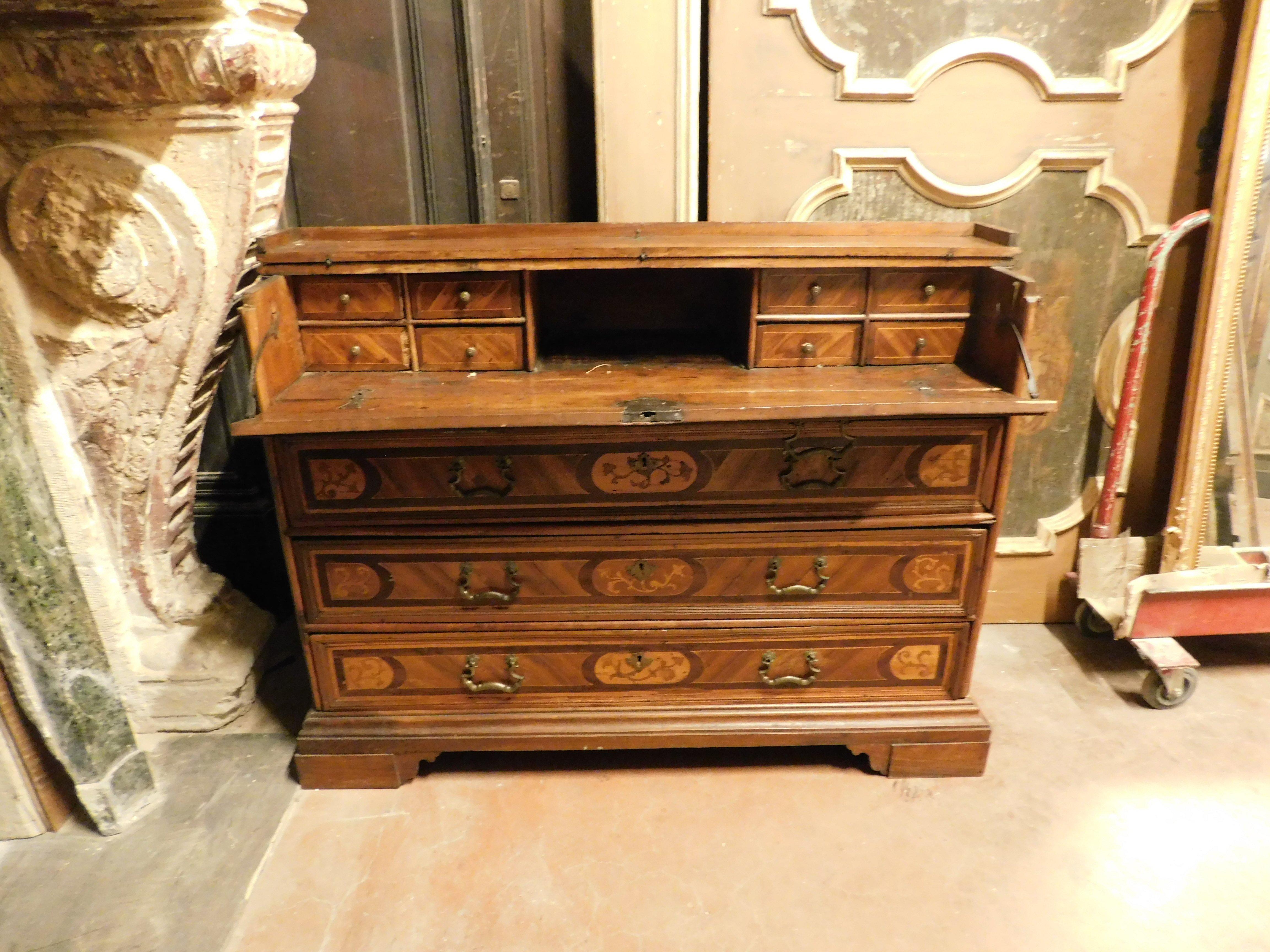 Antica cassettiera pieghevole, cassettiera in noce antico con ricchi intarsi in evidenza, ha tre cassetti filettati intarsiati con eleganti elementi vegetali e uccelli.
Il piano pieghevole nasconde cassetti anch'essi intarsiati, completi di maniglie