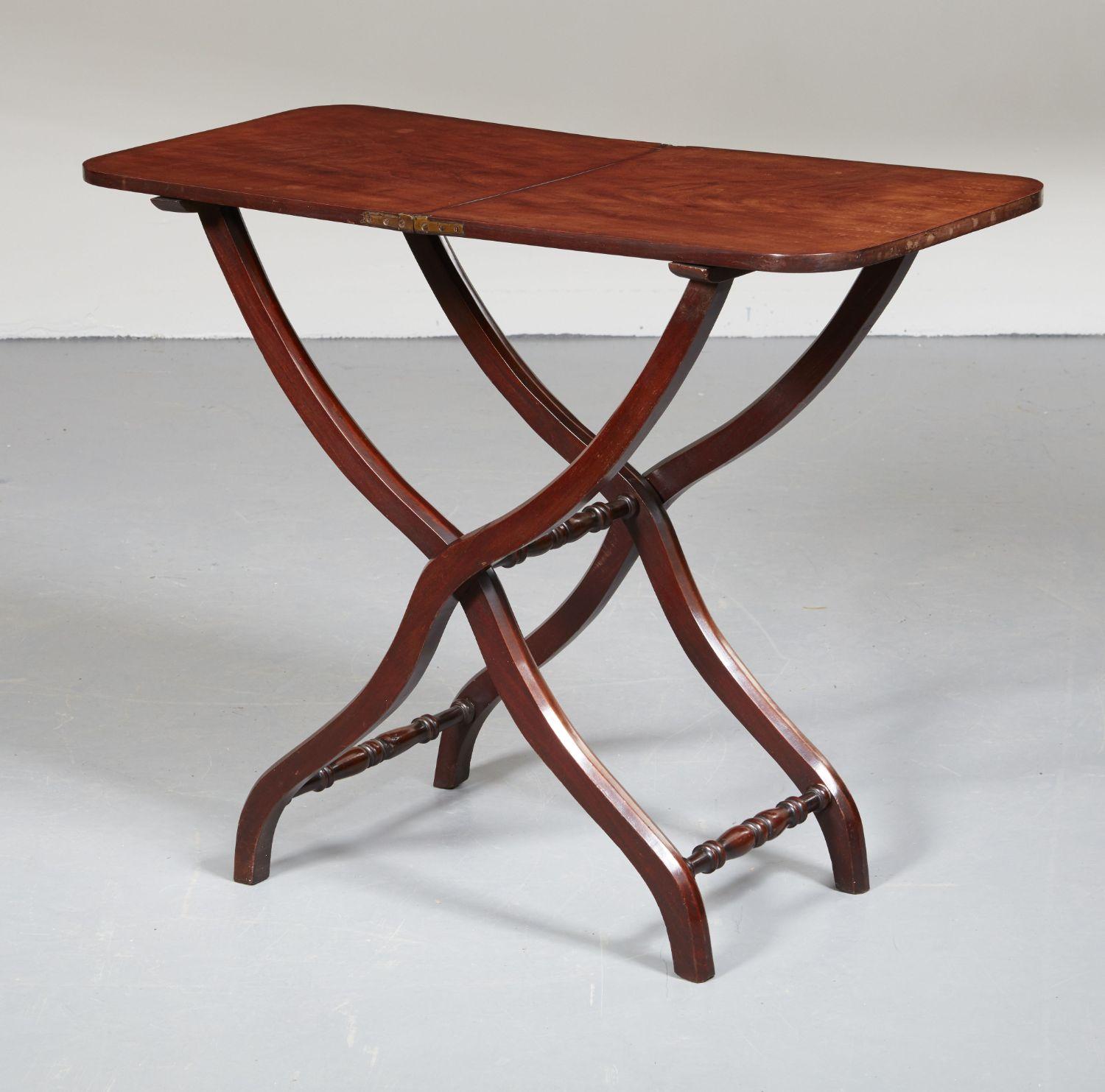 A mid-19th century English folding or coaching table in mahogany with scissor action X-frame legs. Easily portable for use around the house or on the terrace. High quality timber and brass hinges. Good color and elegant stance.