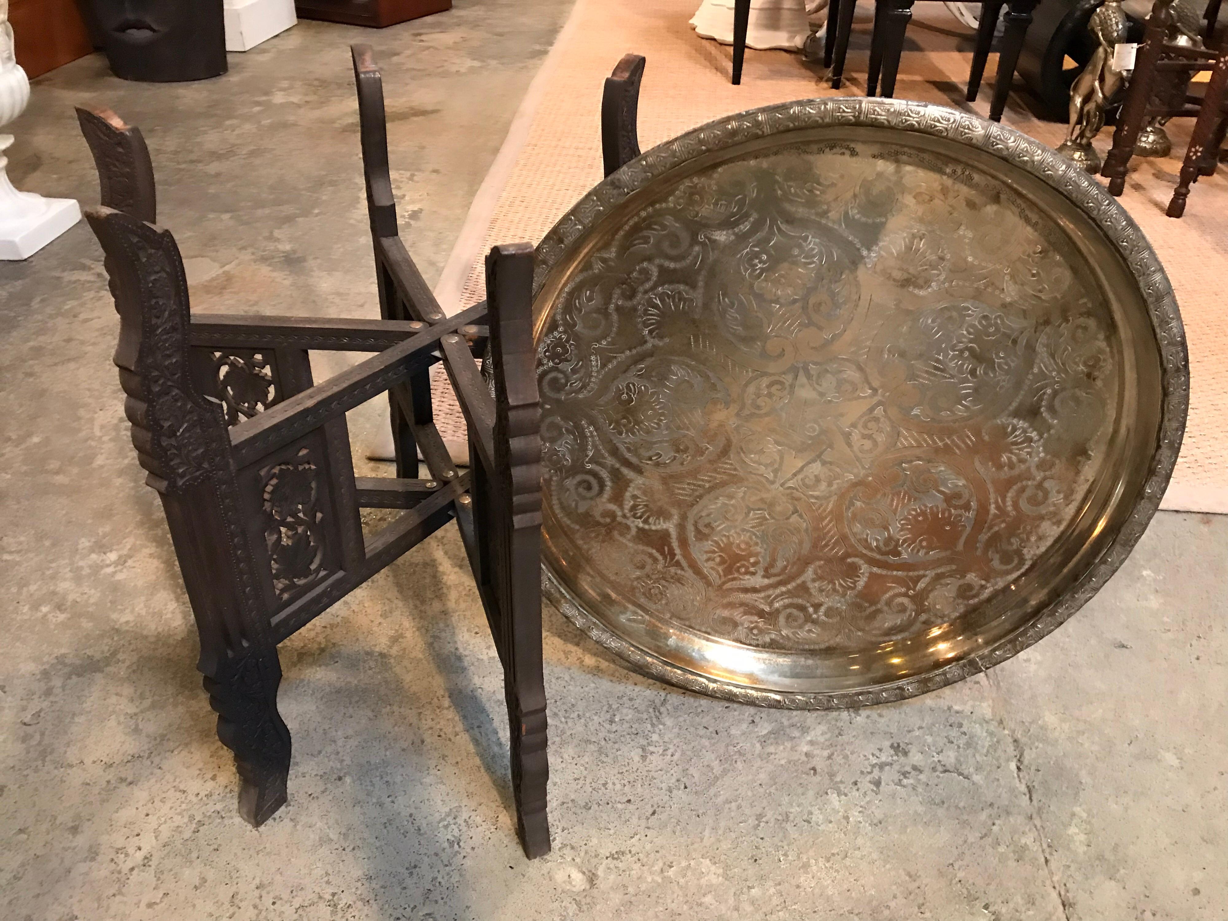 This Moroccan table has both Indian and Egyptian stylings. It is a six legged table that can fold flat into 2 legs. Exotic carvings and patterns are on display throughout.