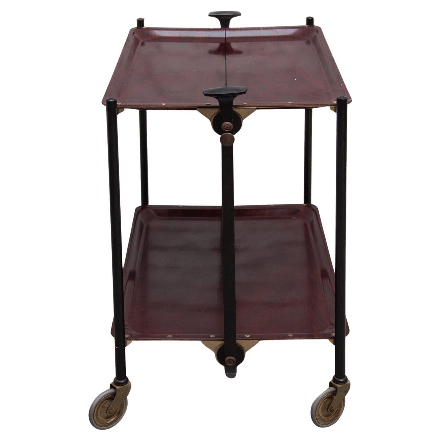 Original Bremshey bar or serving cart designed in Germany. Super stylish clean and multifunctional design. The bar cart can be folded in two positions and easily stored. Made of formica laminate teak wood pattern. The bar cart is in original good