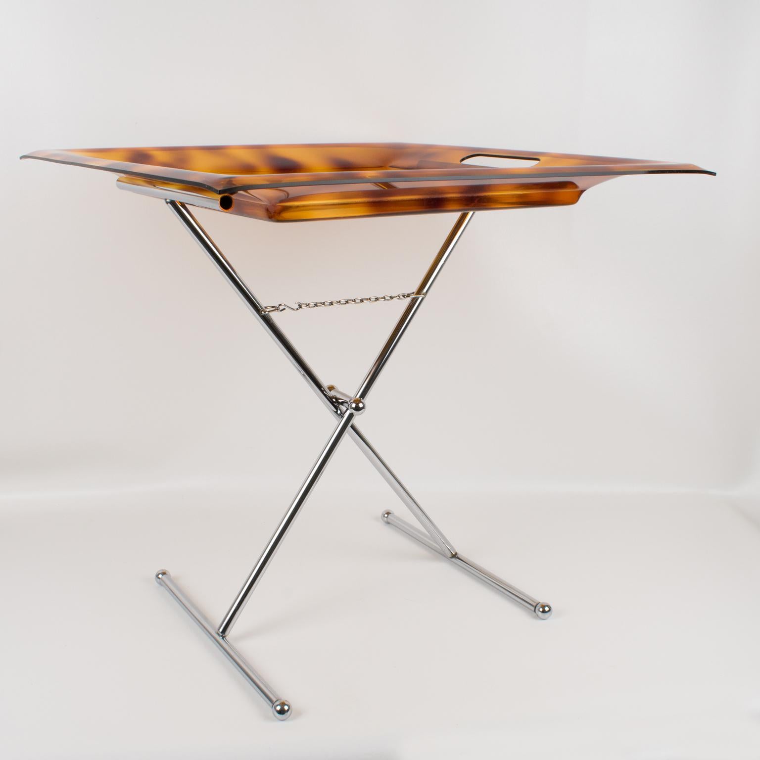 A lovely modernist 1980s Italian folding side tray table. Extra-large square-shaped butler tray with raised edges in Lucite with a faux tortoiseshell (tortoise) pattern. Chromed metal folding X-stand. Perfect for barware, cocktail serving, or any