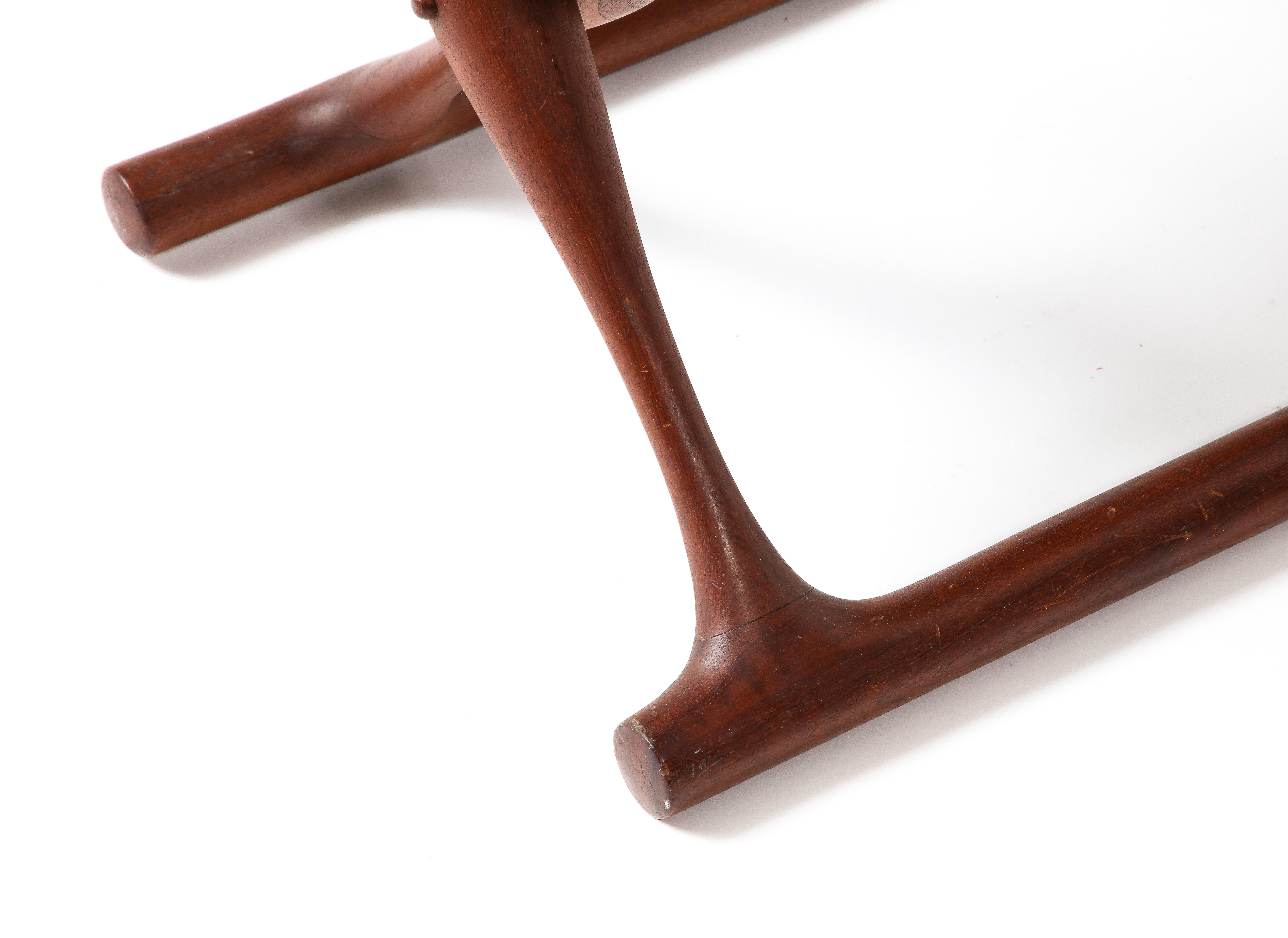 Folding curved teak and black leather stool.
