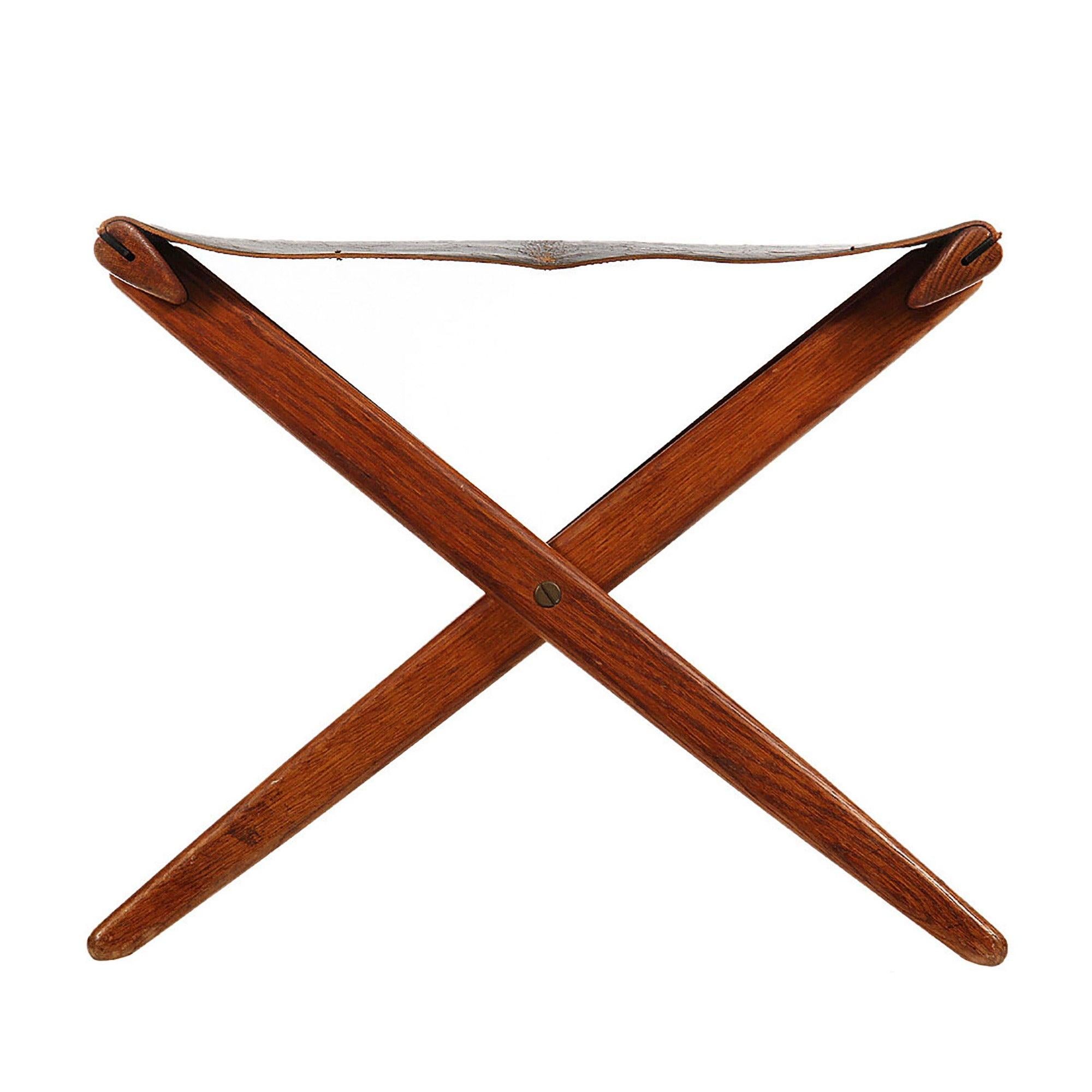 Tabouret pliant en chêne Foldes avec siège en cuir noir d'origine. Le cuir est usé et craquelé.