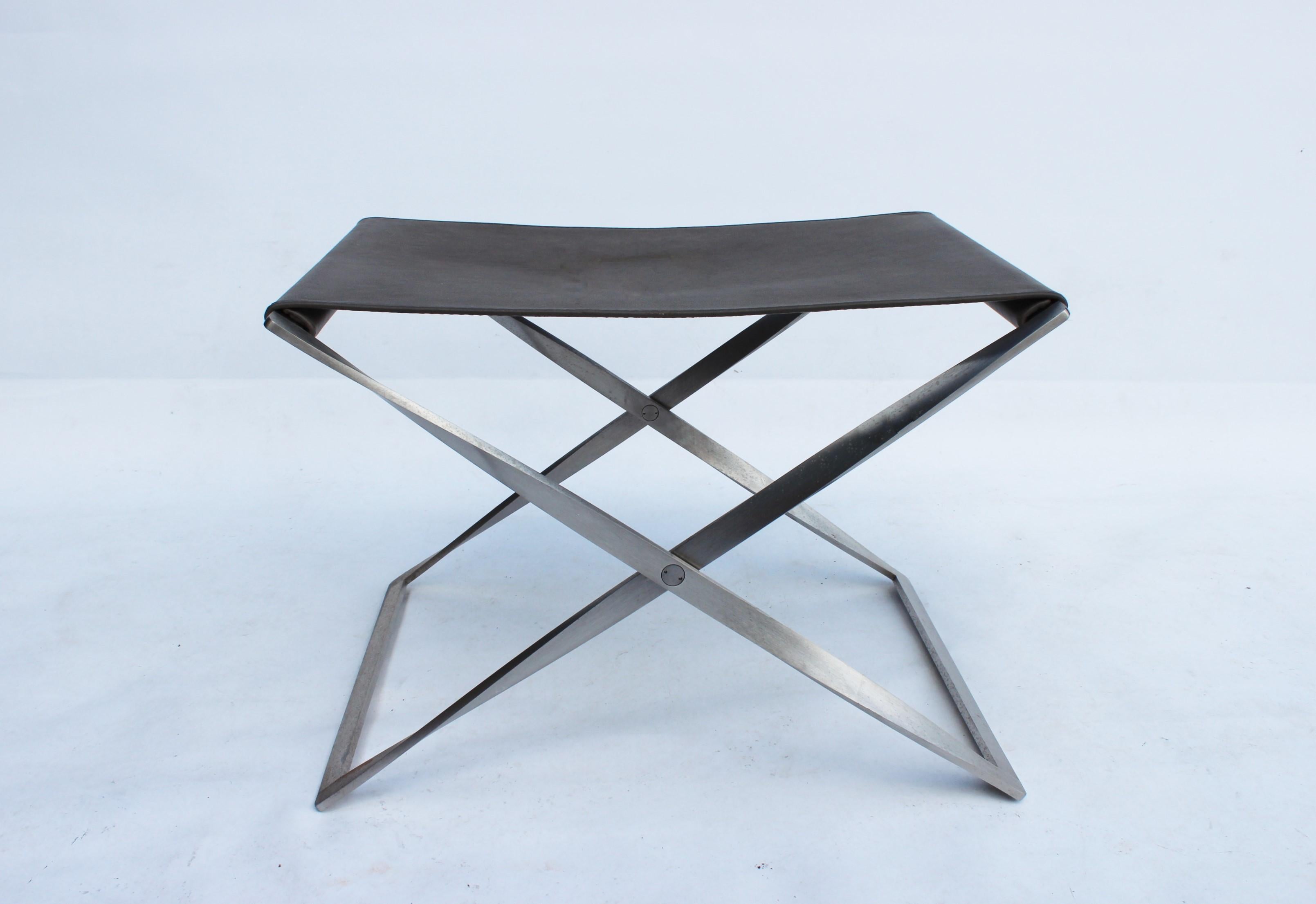 Folding stool, model PK91, designed by Poul Kjærholm in 1961 and manufactured by Fritz Hansen in 2019. The stool is with original upholstery in grey leather and frame of steel.