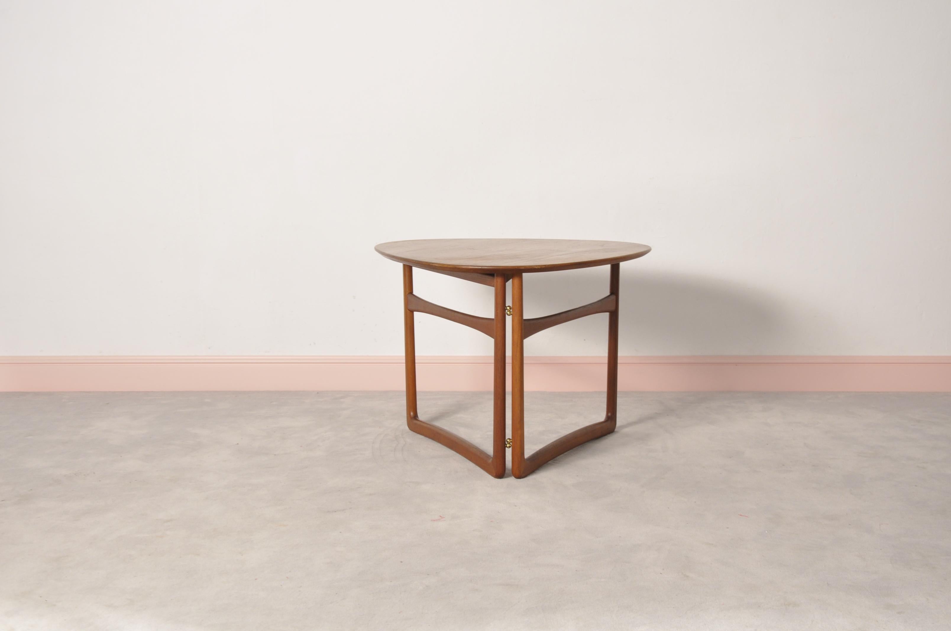 A model FD 18/57 teak folding or side table designed by Peter Hvidt and Orla Mølgaard-Nielsen for France & Daverkosen, circa 1950s. Featuring a triangular teak top with bevelled edge and rounded corners supported by a collapsible solid teak sled