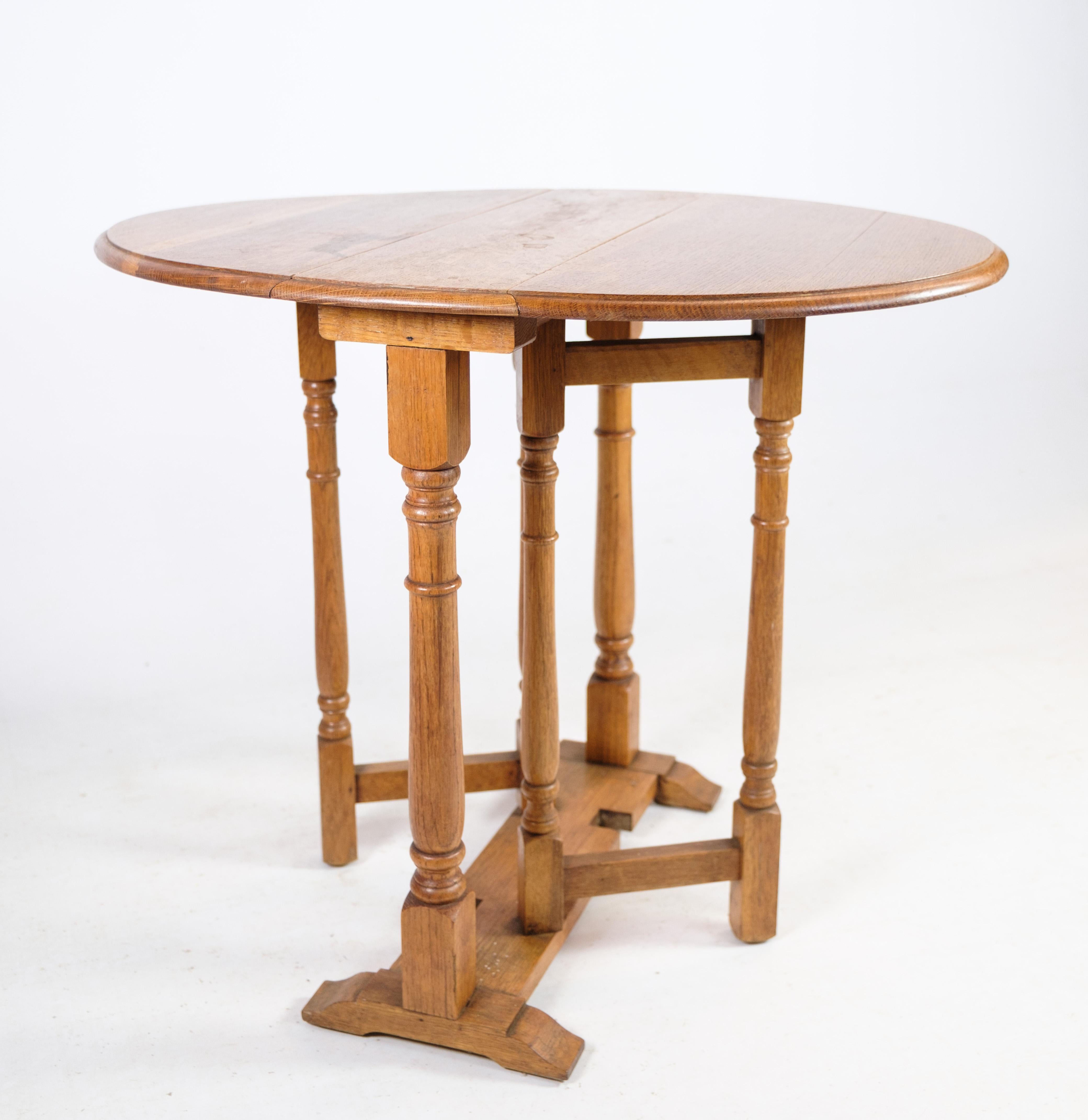 Cette exquise table pliante remonte à la fin du XIXe siècle et présente l'élégance intemporelle et la robustesse de l'artisanat caractéristiques de l'ère victorienne. Fabriquée en bois de chêne massif, cette table dégage chaleur et caractère, avec