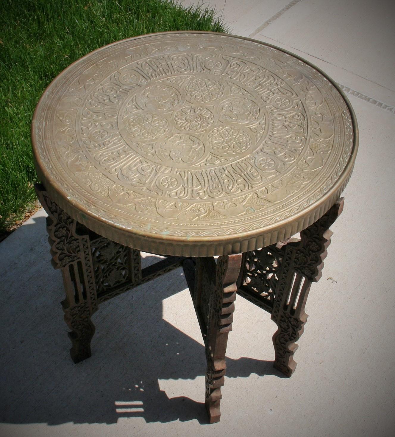 3-571 Hand hammered brass top table with hand carved wood base. Foldable for easy storage.