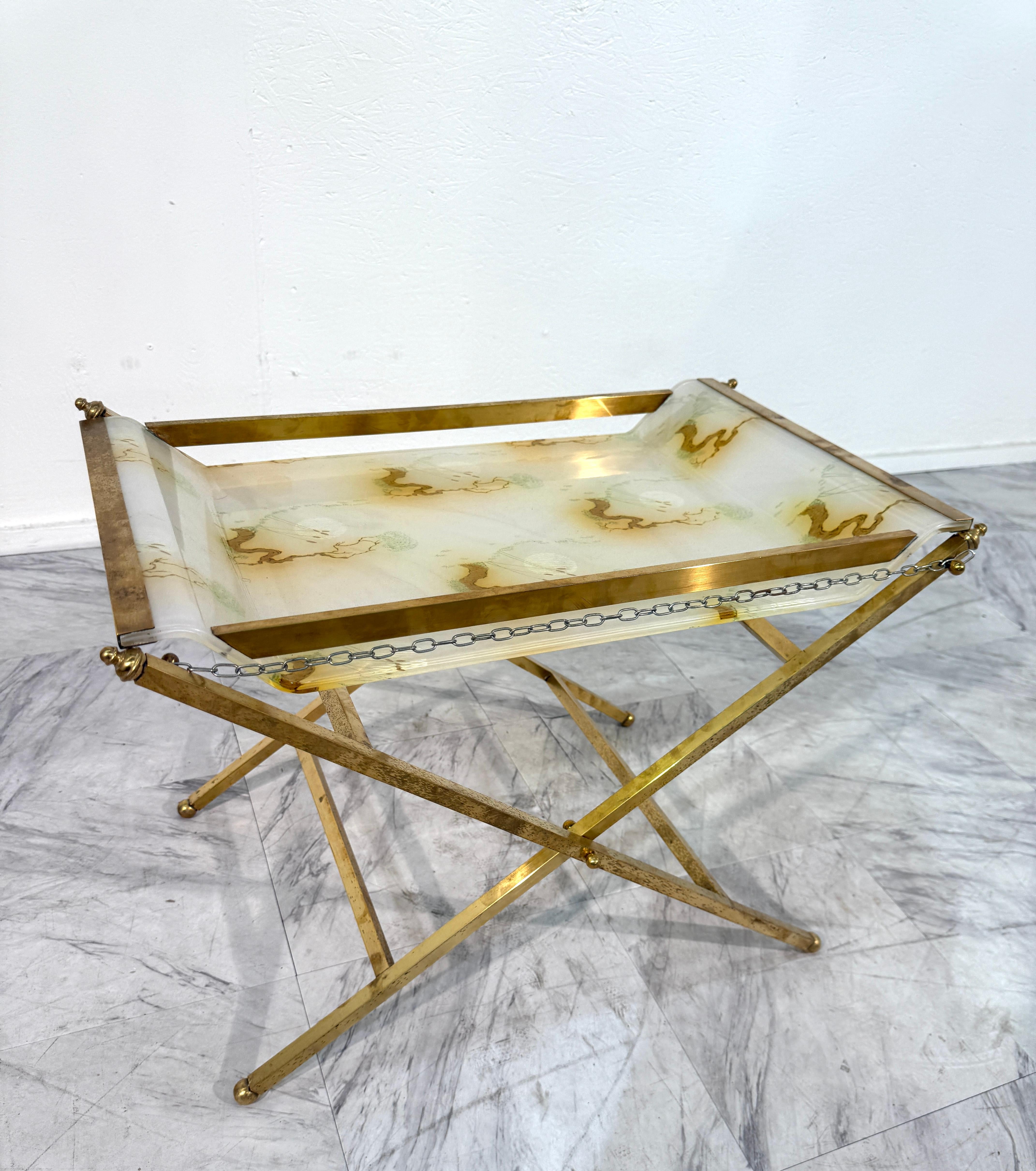 Eleganter klappbarer Tabletttisch mit klappbarem Messingfuß und abnehmbarer Glasplatte. Das Tablett ist mit einem sanft marmorierten Muster in warmen Beige-, Grün- und Goldtönen verziert, was dem Stück sowohl Zartheit als auch Charakter