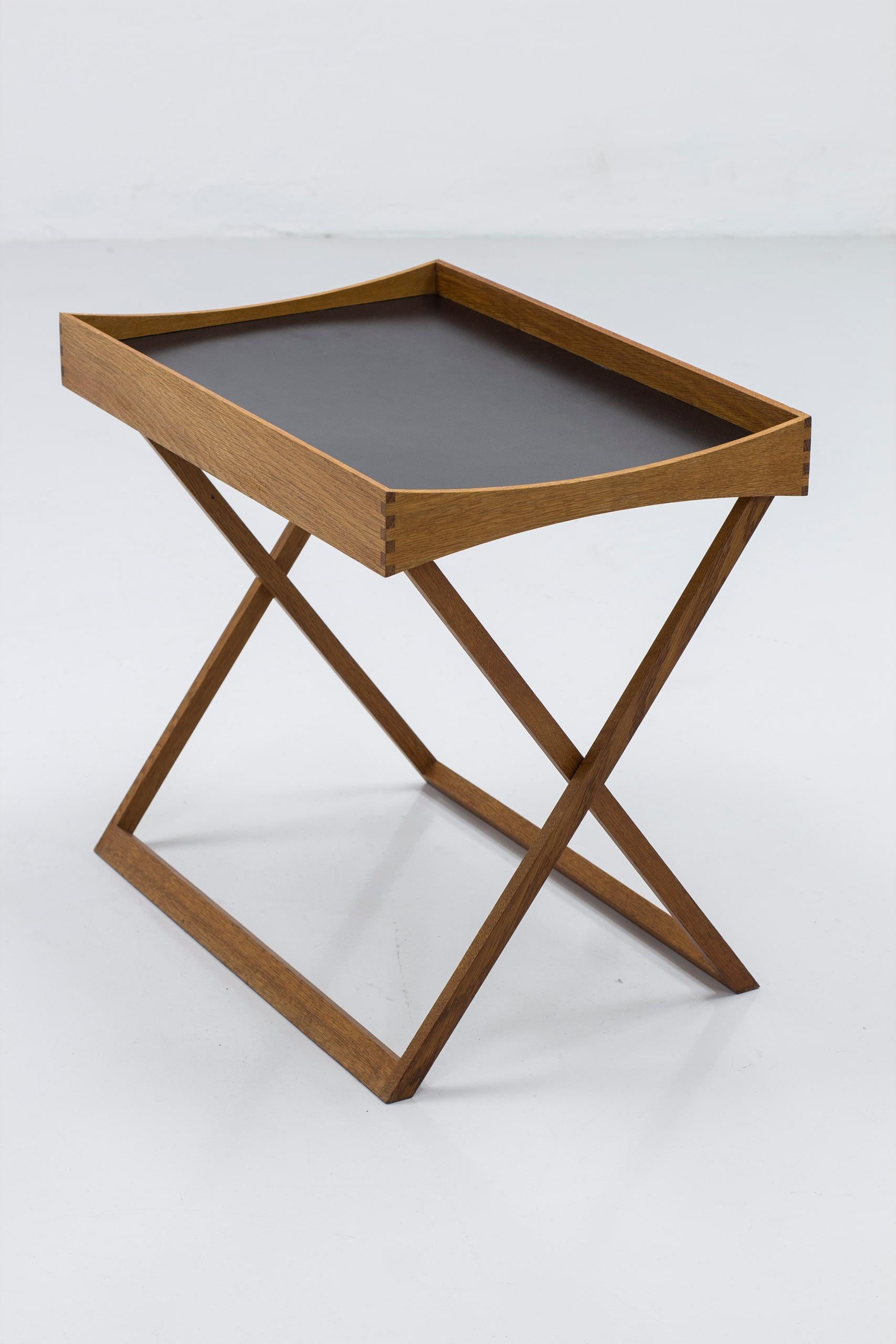 Danish modern folding tray table designed by Torsten Johansson. Produced in Denmark by Bo-Ex, ca 1963. Made from solid oiled oak with finger joinery and black formica top on one side and oak veneer on the other. Easily folds together to store away.