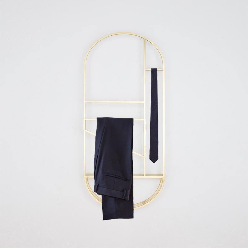 The FOLDWORK VALET by STUDIO BERG is a crossbreed between a wall sculpture, inspired by half-timbered constructions, and a valet stand. It hangs on the wall, has a shelf for accessories, an arch for jackets and a hanger which can be folded out to