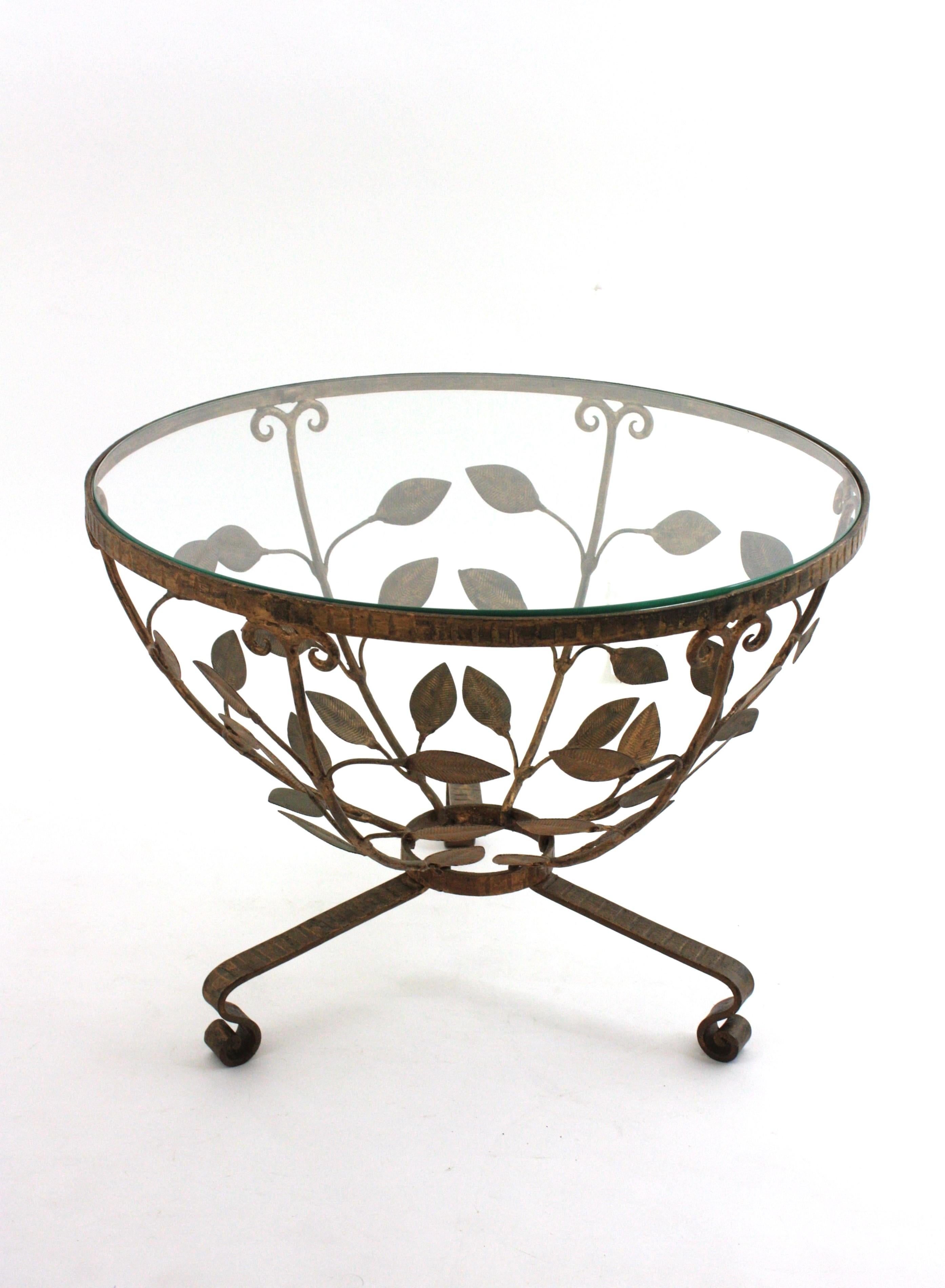 Spanish Round Coffee or Cocktails Table / Side Table with Foliage Design, 
One of a kind Leaves Iron Low Table. Manufactured by Ferro Art, Spain, 1940-1950
Materials: Iron, Gold Leaf, Glass
Stunning Hollywood Regency wrought gilt iron  tripod table