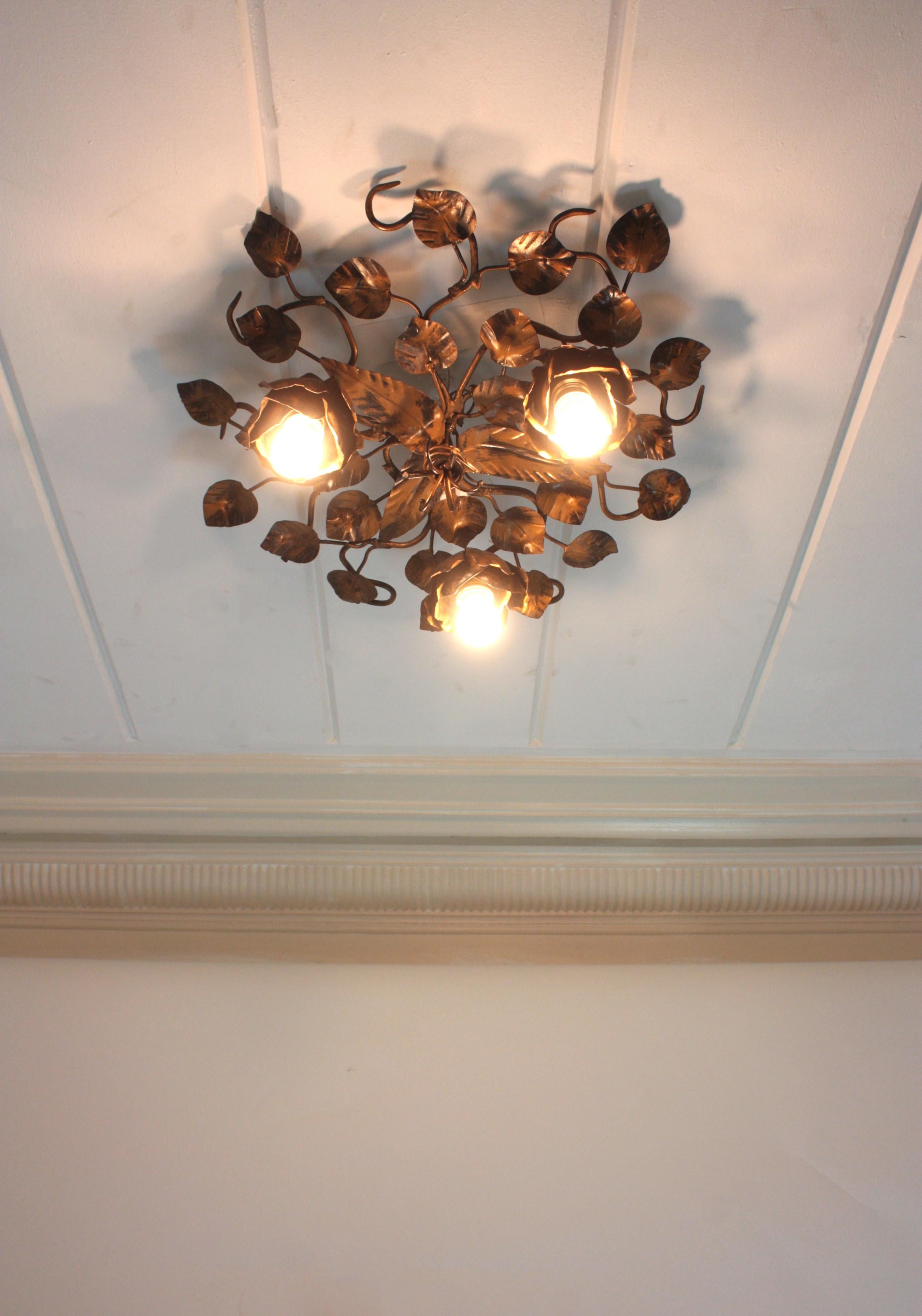 Rosebush Tree Foliage Floral Light Fixture in Gilt Patinated Iron, Three Lights.
Monumental rosebush floral flush mount / wall light with roses and leaves in patinated bronze gilt metal. Spain, 1950-1960.
This hand-hammered iron foliage floral light
