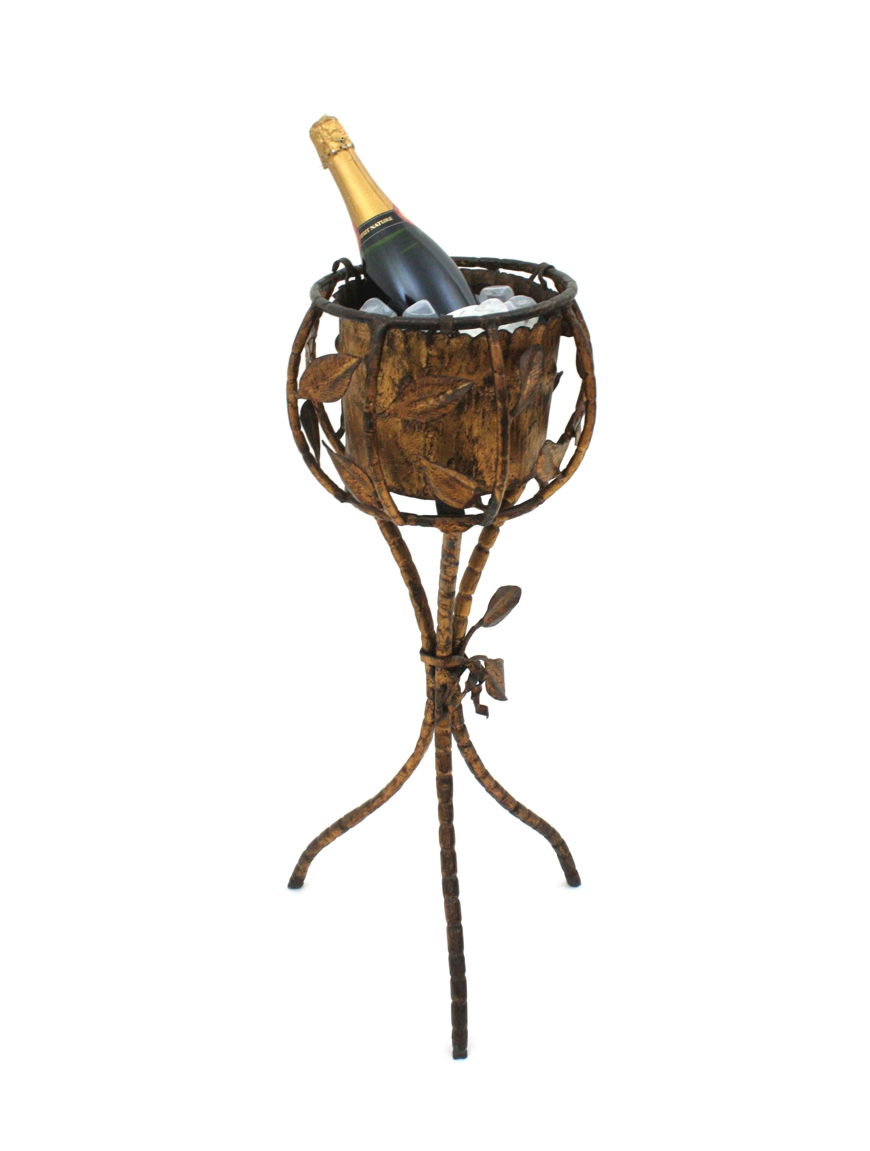 Pie de trípode de hierro forjado dorado único en su género, Francia, años 30-1940
Jardinera, cubitera enfriadora de vino o champán sobre base trípode con detalles decorativos de follaje. 
Este juego de trípode para servir bebidas está hecho a mano