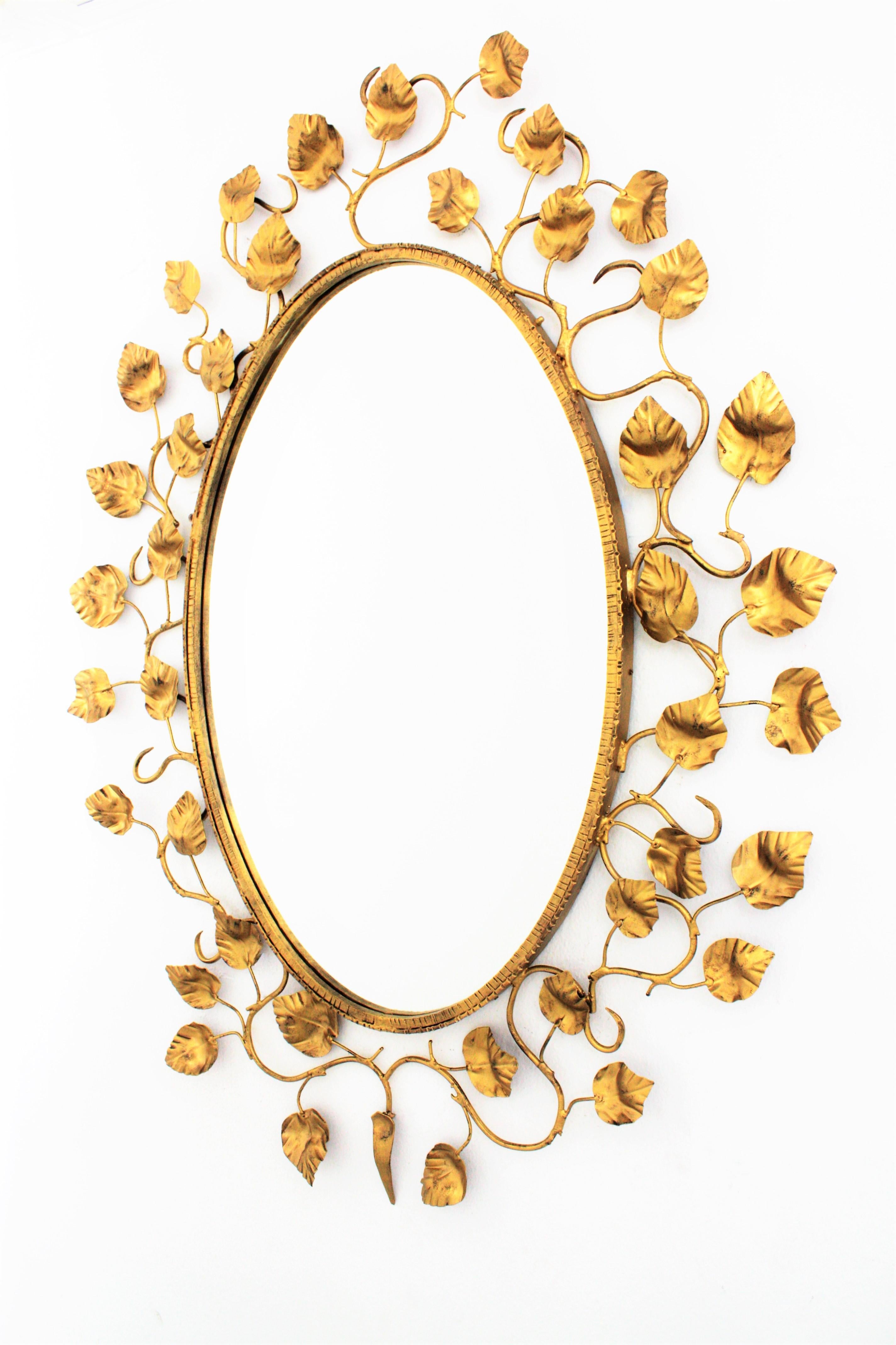 Doré Grand miroir ovale espagnol avec cadre en fer doré et feuillage, années 1950 en vente