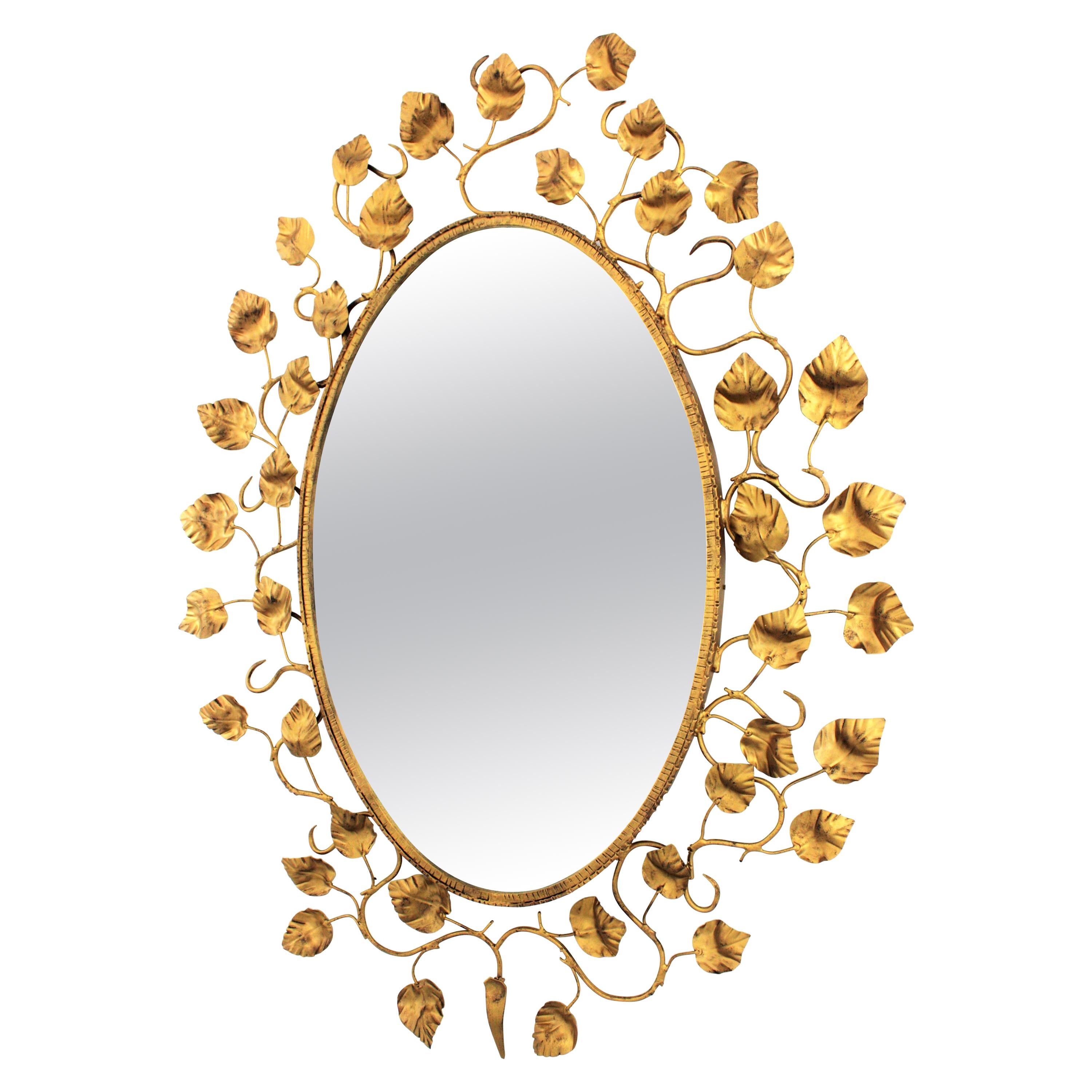 Miroir ovale Foliage en métal doré, années 1950
Grand miroir ovale en fer doré avec encadrement de feuillage. Espagne, années 1950-1960.
Ce miroir ovale présente un cadre très décoratif composé de branches et de feuilles en fer doré. 
Sa grande
