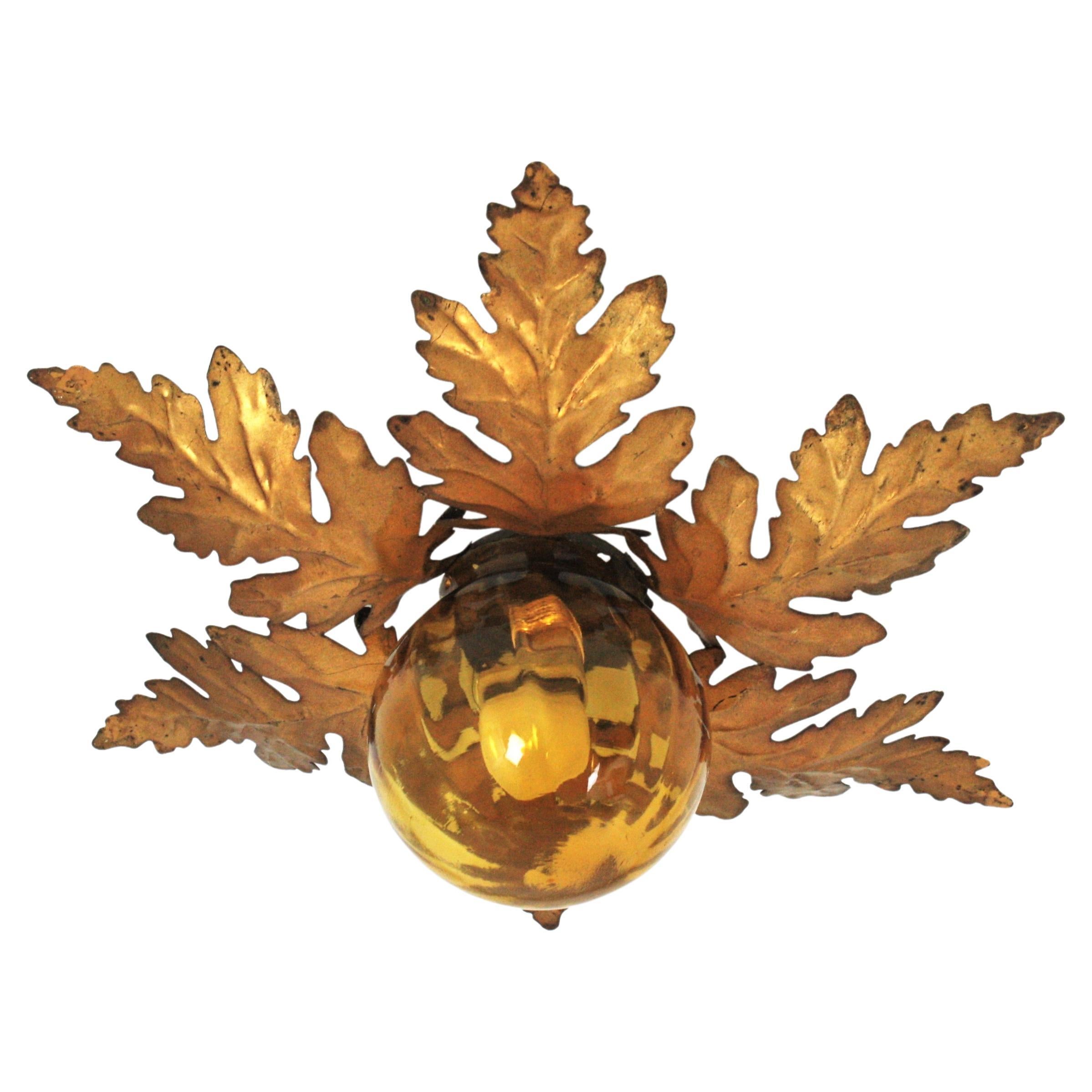 Beautiful flush mount or wall light with handblown amber glass globe shade and foliage frame. Manufactured by Ferro Art, Spain, 1960s.
This lovely ceiling light has a nice design with branches and leaves surrounding a central glass globe shade in