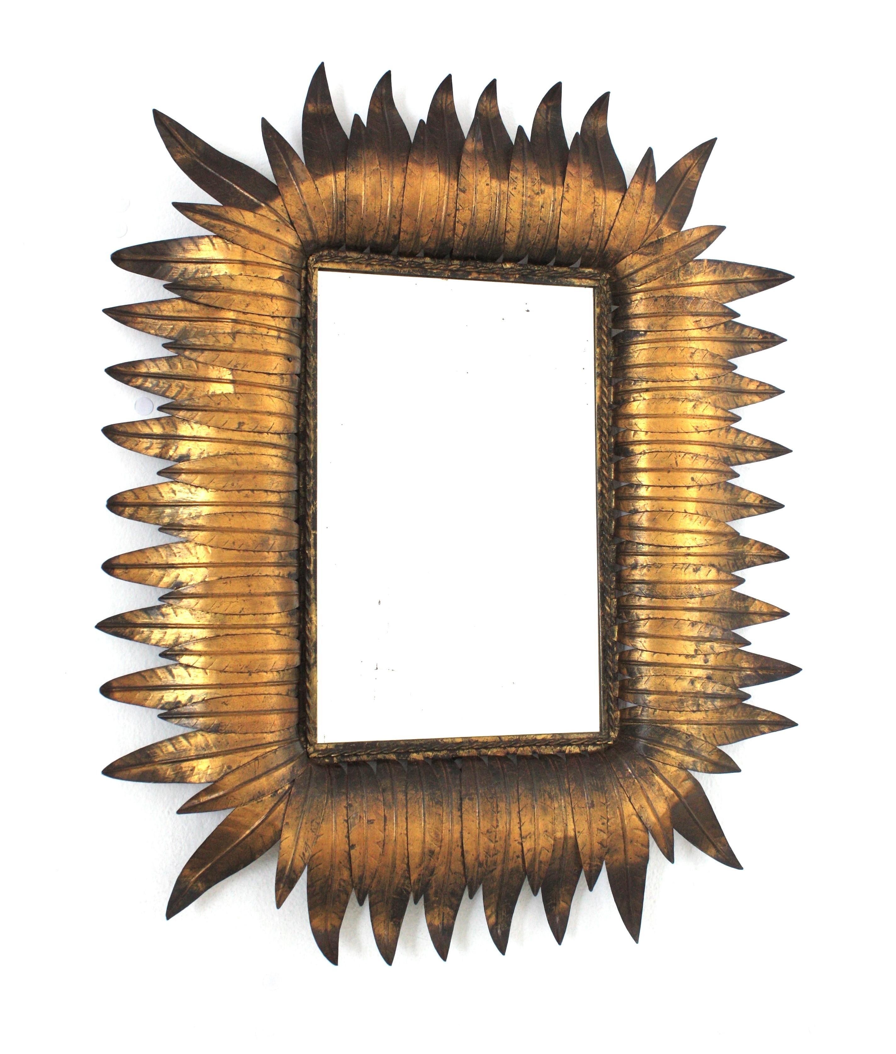 Specchio da parete a foglia di sole in ferro martellato a mano con finitura a foglia d'oro, Spagna, anni 1950.
Specchio rettangolare altamente decorativo con foglie incorniciate in due dimensioni e doratura a foglia d'oro.
Interamente realizzato a