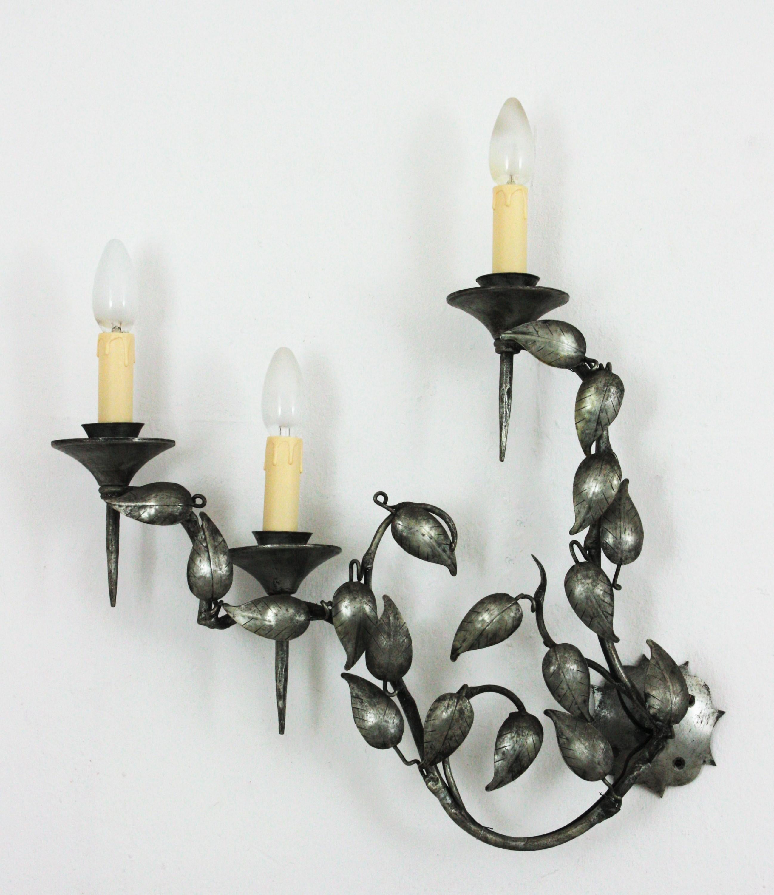 Leaves wall sconce with 3 torch shaped lights patinated in silver with foliage design. Spain, 1950s.
This outstanding wall light features an intrincate of leaves with branches holding 3 torch shaped bulb candle shaped holders.
Silver leaf and