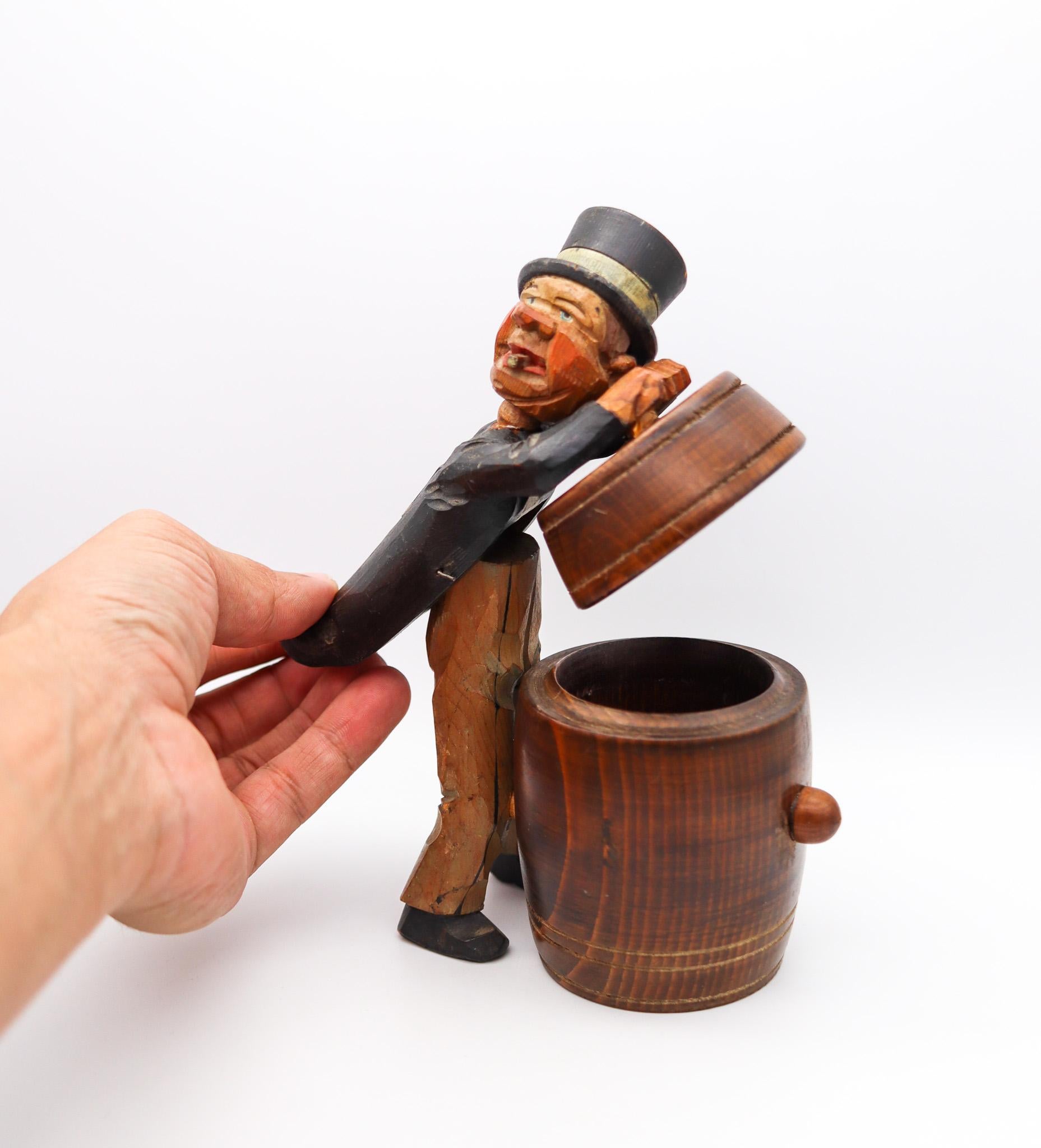 Folk art desk barrel box.

Very unusual piece of folk art, created around the 1930. This is a mechanical desk barrel box carved in wood and decorated with painting. Shown a man dressed in a tuxedo and a hat smoking a cigarette which rest over a