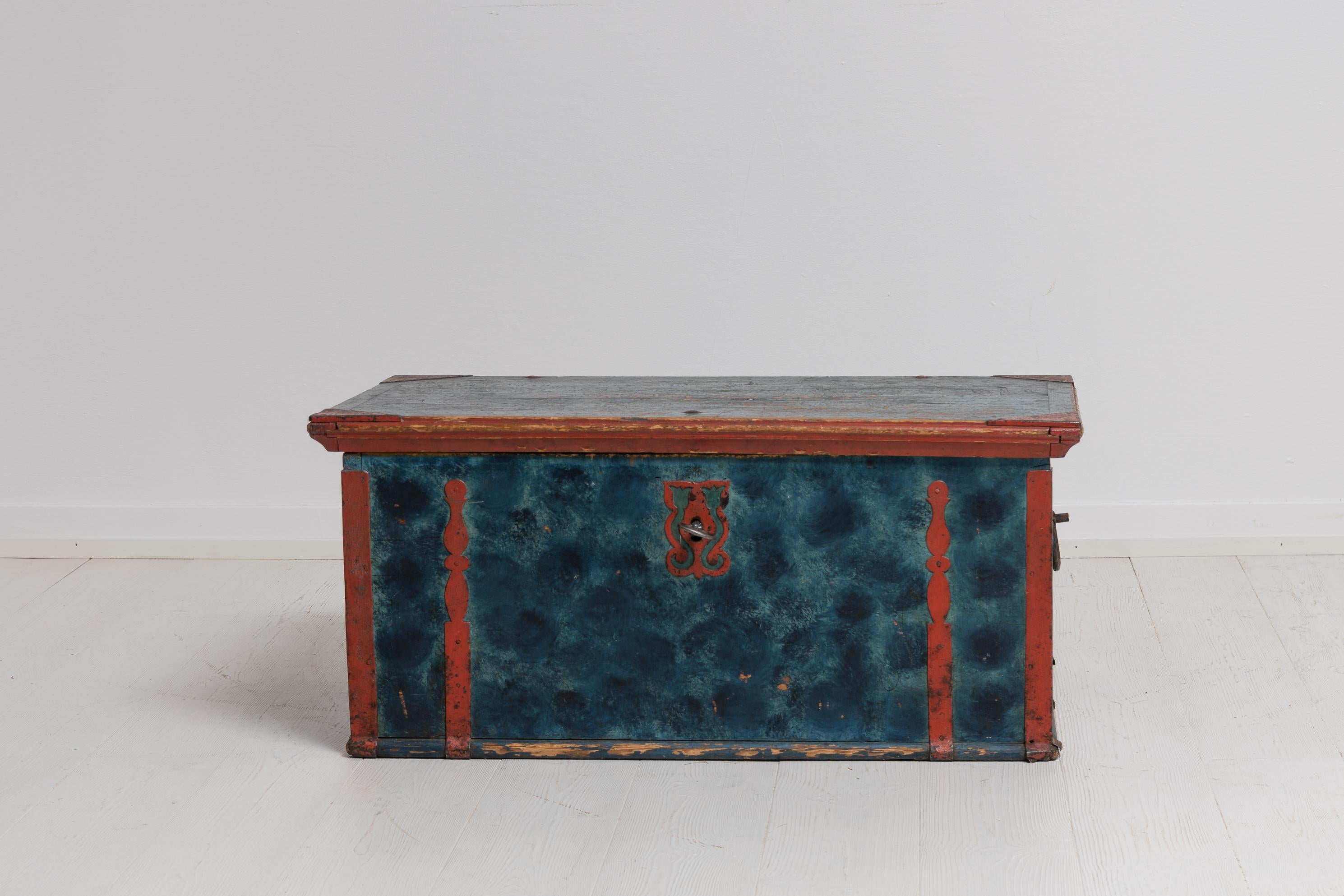 Blue folk art chest made in Swedish pine. The chest from northern Sweden and has hand wrought reinforcements in iron. The chest is unusually painted with blue faux paint which is also the original first layer of paint. Dated 1822 and with painted