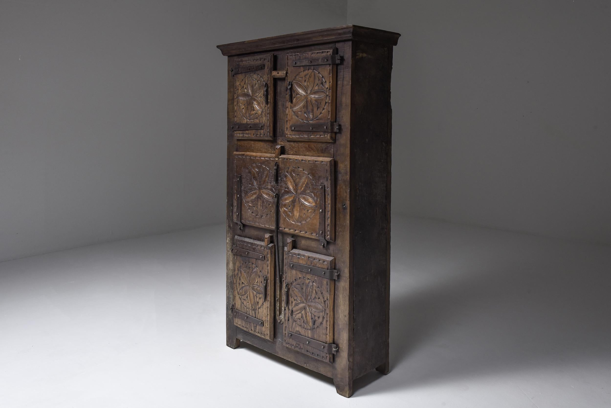 19th-century travail populaire cabinet from Bretagne, France. Reflecting the essence of French Wabi Sabi, this solid wood armoirette embodies the zen-like harmony and refined simplicity of folk art. Adorned with delicate sand dollar carvings, this