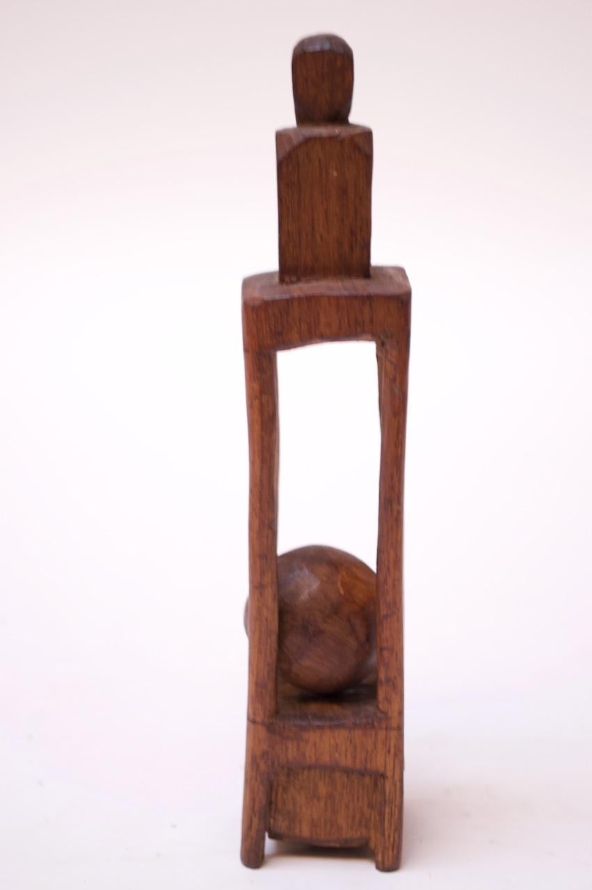 Folk Art whimsy 'ball in cage' sculpture whittled from one continuous piece of wood, circa 1910-1920. The carved supports holding the ball in place lack symmetry and refinement, enhancing the crude / outsider style of the work.
Appealing decorative