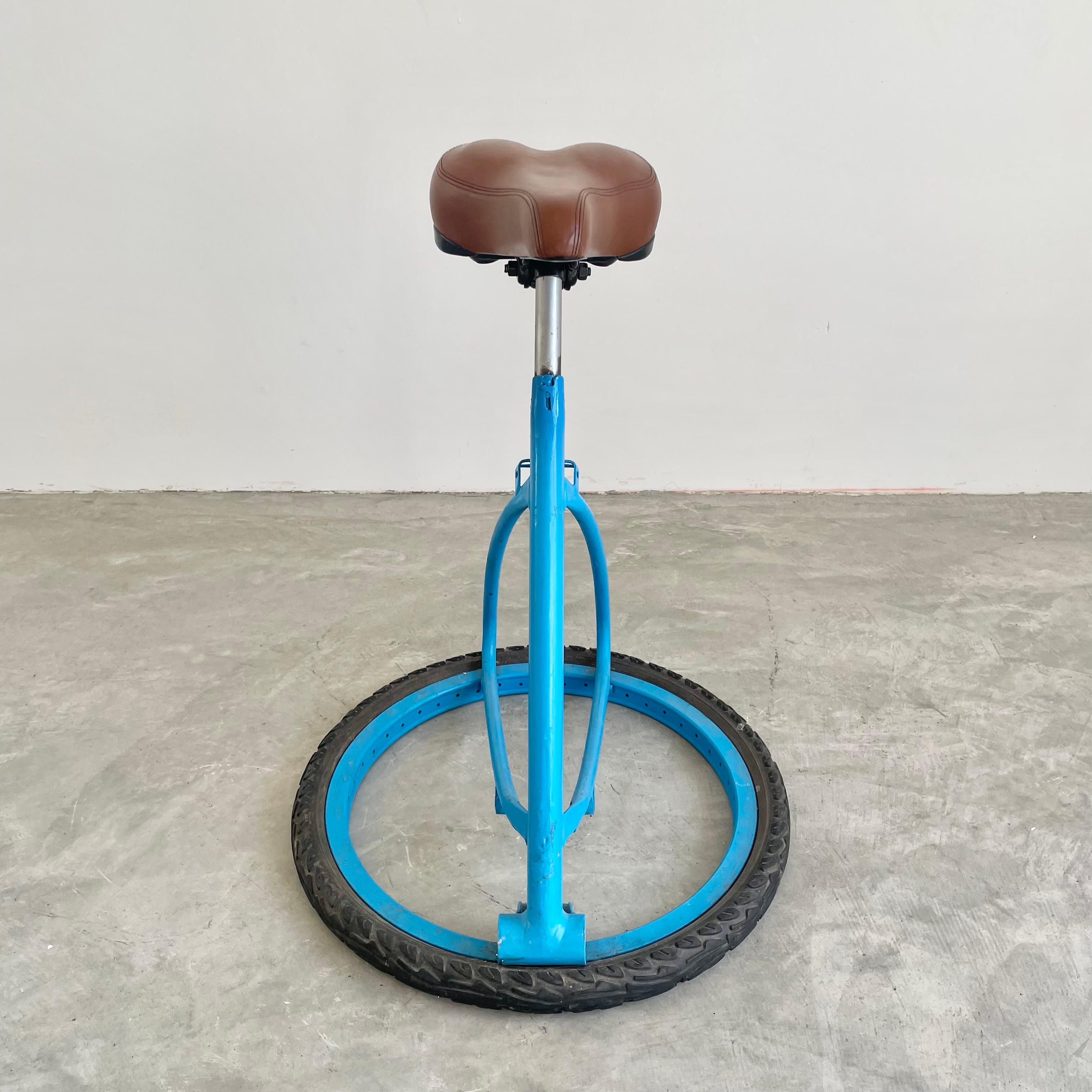 Unique bicycle style stool made in France, circa 1980s. Unique design with great contrasting colors from the brown seat to the electric blue body and the black rubber base. Perfect patina and age to this piece. Functional stool with a well cushioned