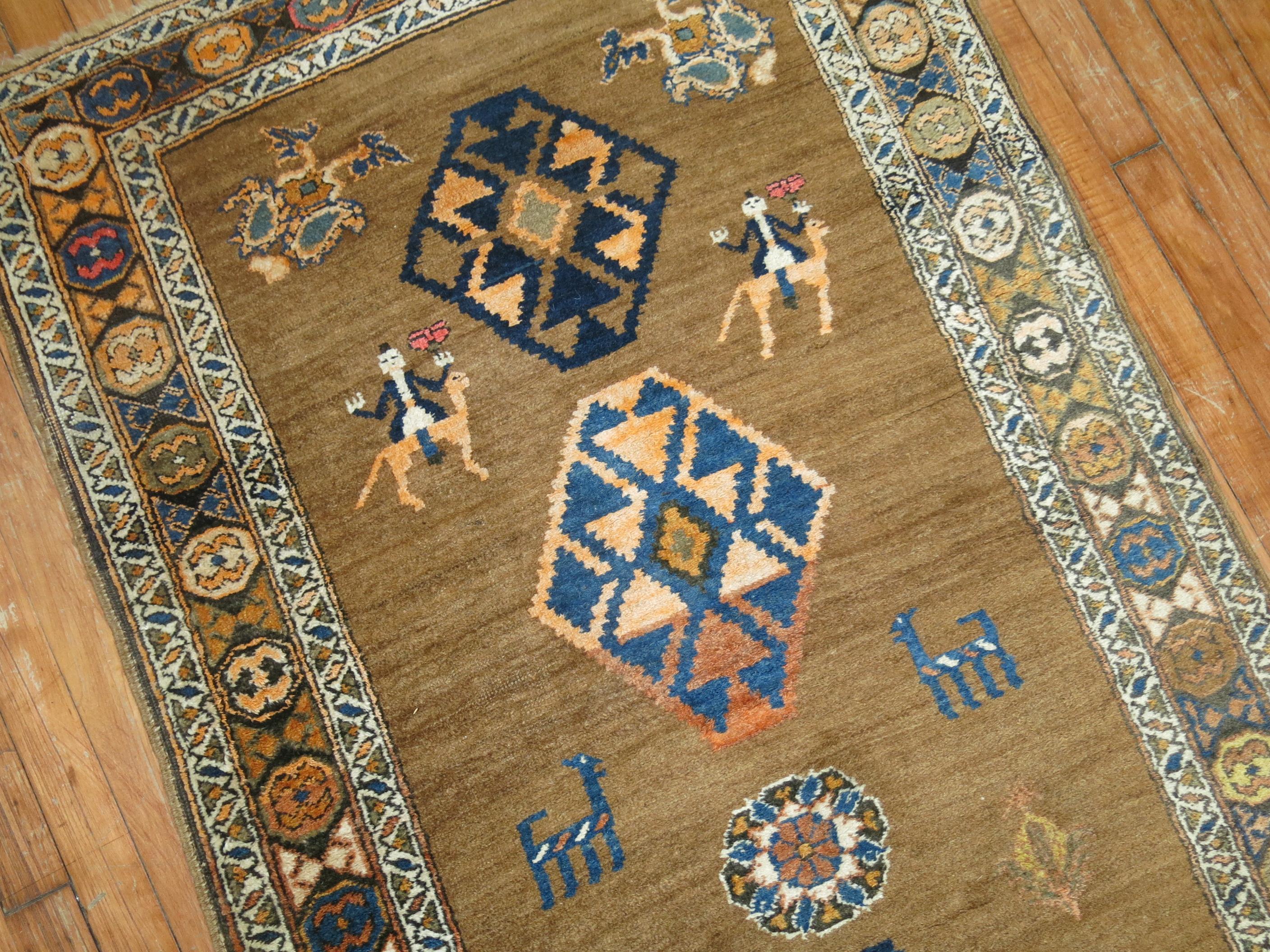 Make a bold statement in a hallway with this early 20th century tribal Persian Serab runner featuring a folksy motif on a camel brown field. Various Animal and Human figures are found within the field. The colors are casual,

circa 1930, measures:
