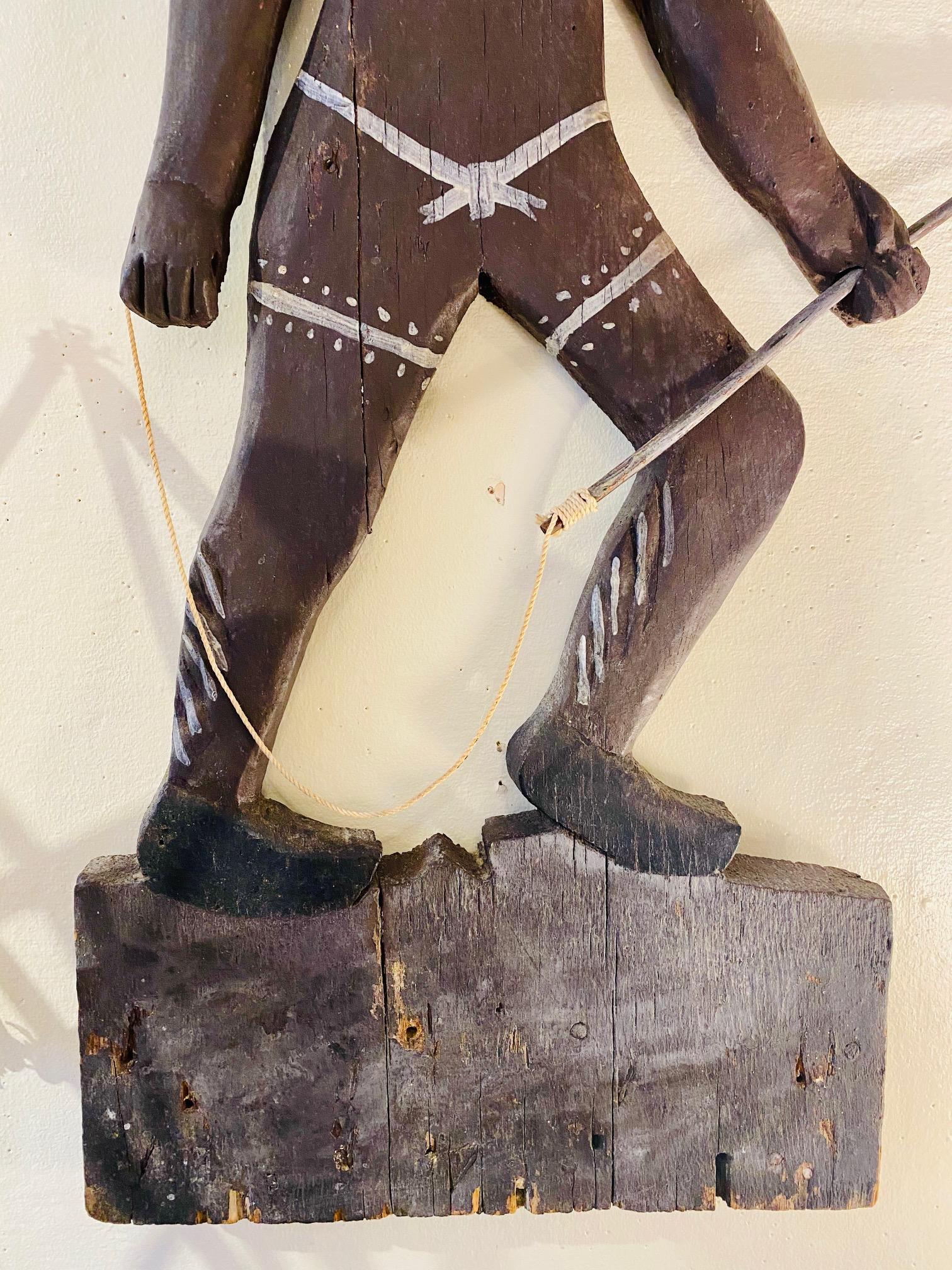 Folk Art Carved and Decorated Plaque of Tashtego, early to mid-20th century, a flat carved panel image of a Native American man, with feather headdress, tattoos and jewelry, bearing a harpoon with line. The image can only be that of Tashtego, the