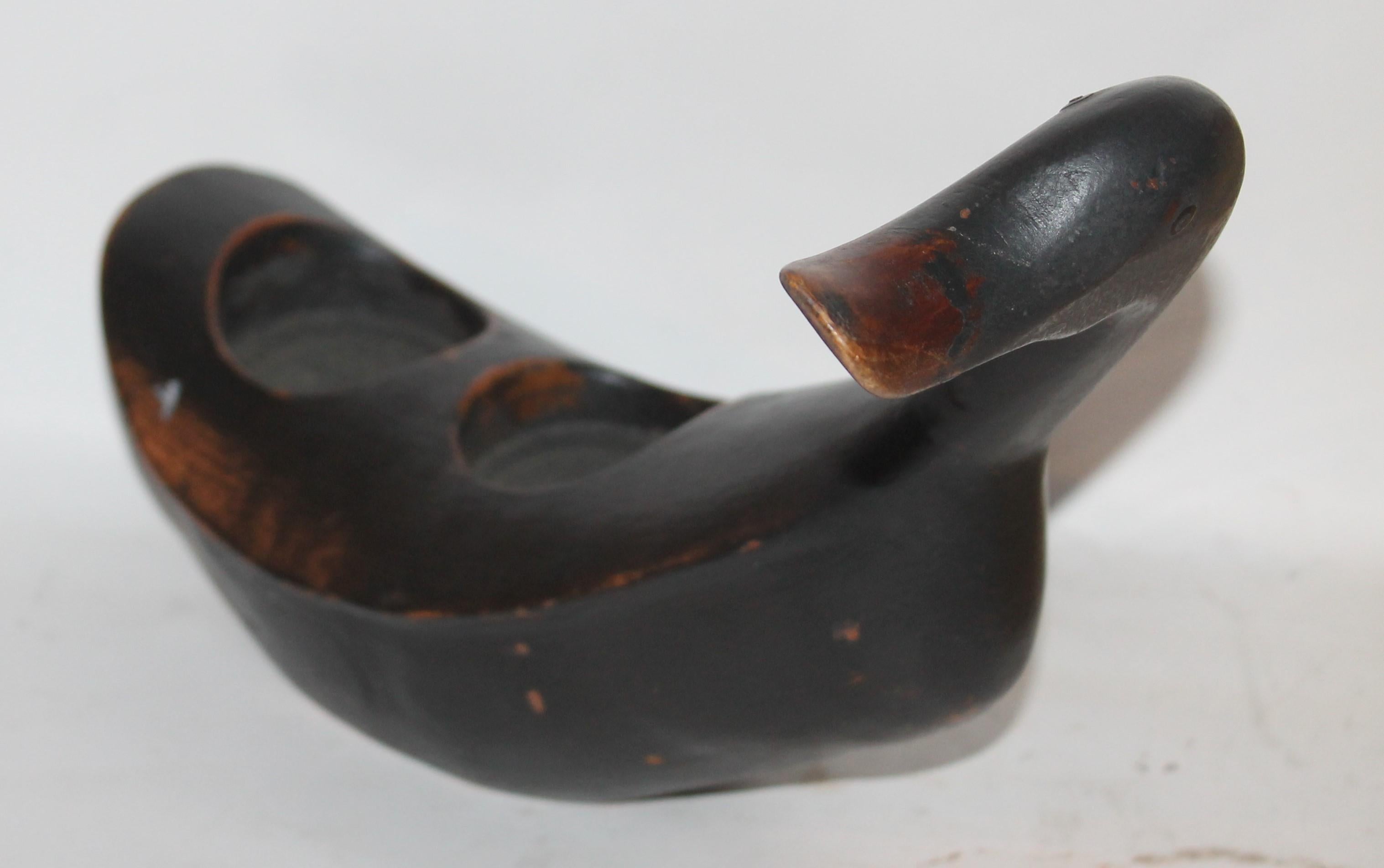 This folky hand carved and painted black duck is in good condition and has odd cutout for drinks or something special.