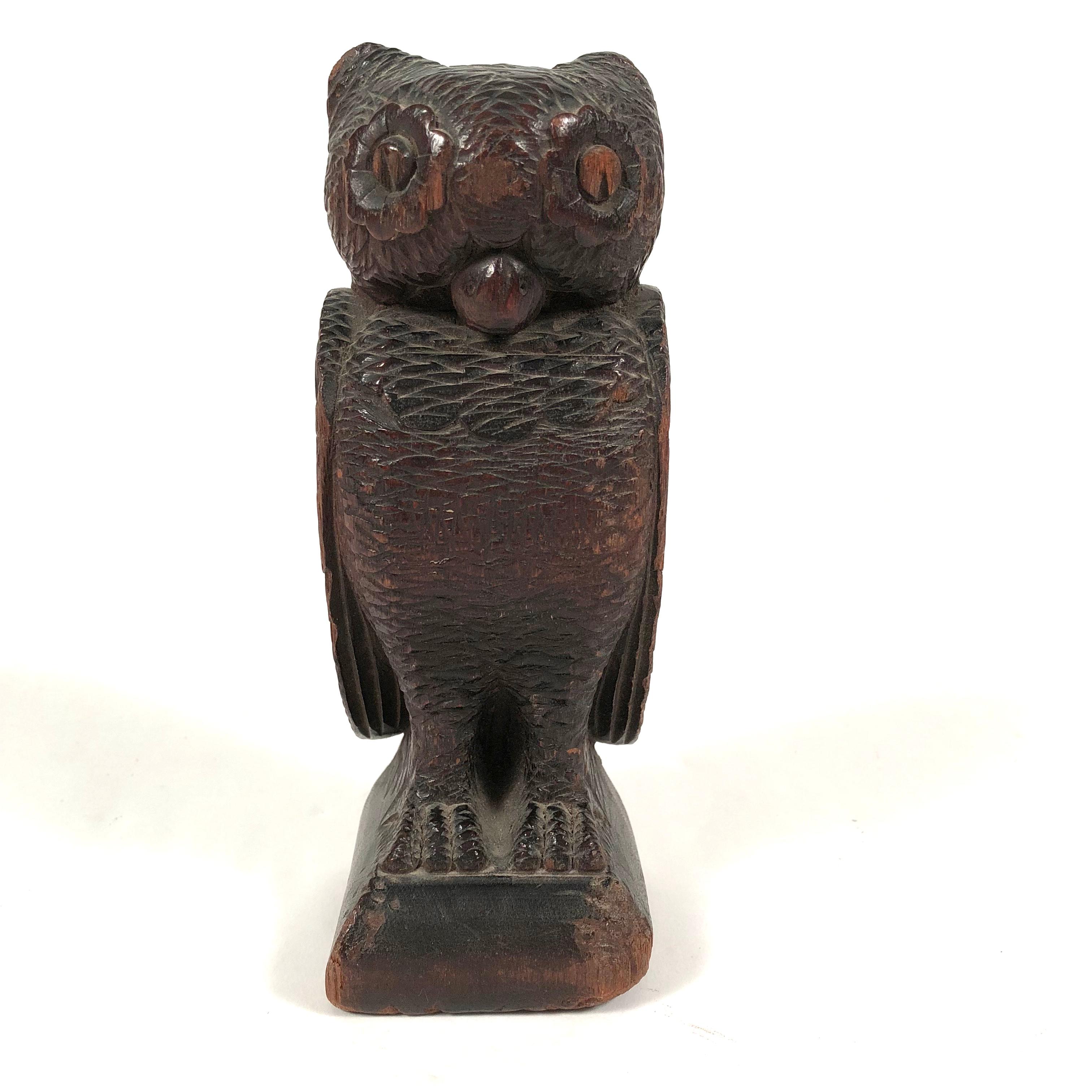 A 19th century Folk Art carved wood sculpture of an owl, facing forward with its wings by its side, animated wide open eyes and head and body with detailed feather and talon carving on 3 sides.